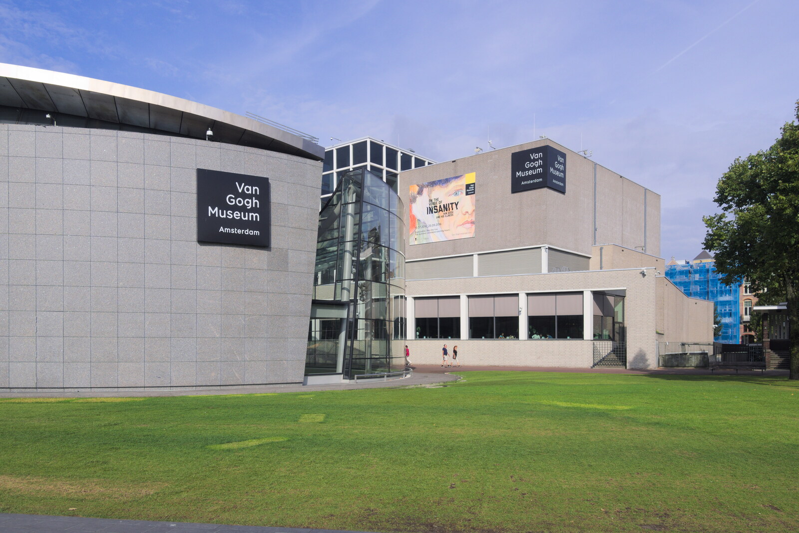 View of the glass wing of the Van Gogh Museum and the concrete building behind it.