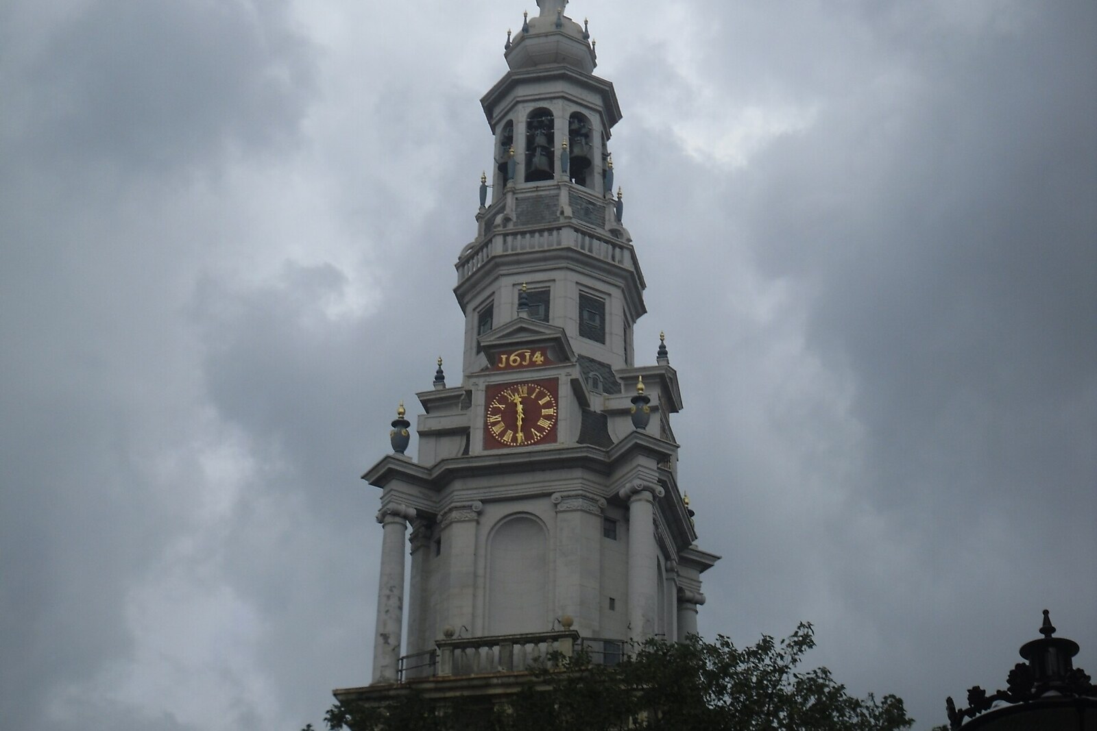 The tall Zuiderkerk tower with its bell tower and spire against a blue sky.
