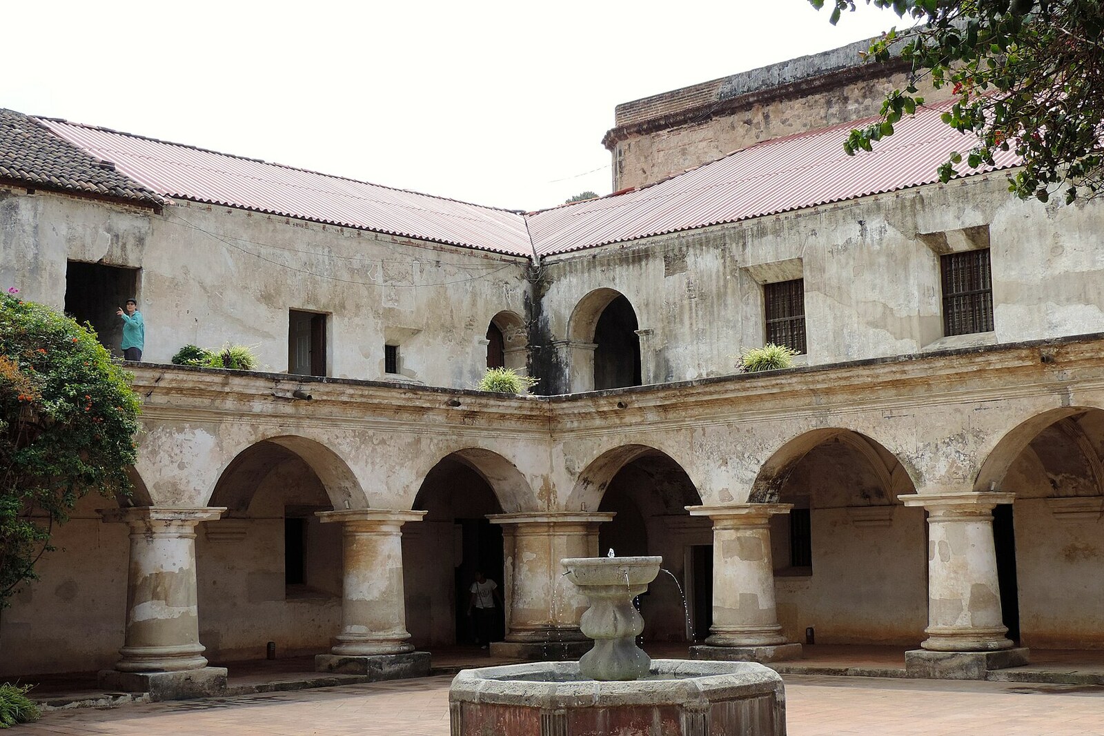 Arcades of the convent courtyard and a stone fountain in the center