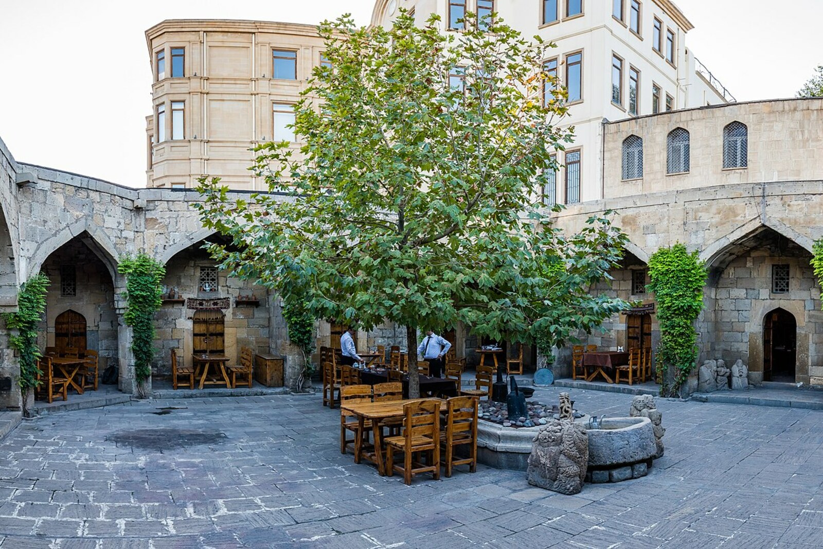 An arcaded courtyard of a Baku caravanserai with a central pool.