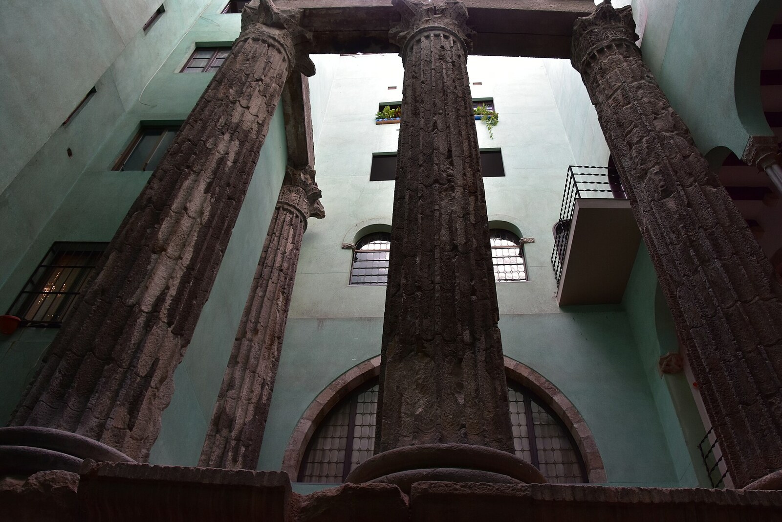 Tall Corinthian columns of a Roman temple rise in a courtyard in Barcelona