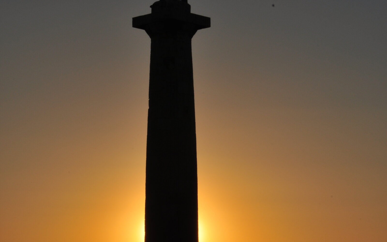 The silhouette of The Victor at the top of the fortress.