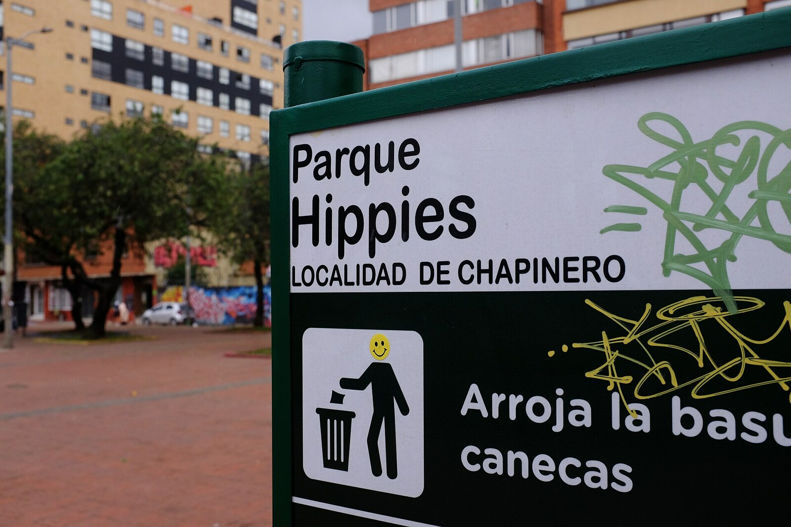 Photograph: Hippies Park—a green square with benches, trees, and a fountain.