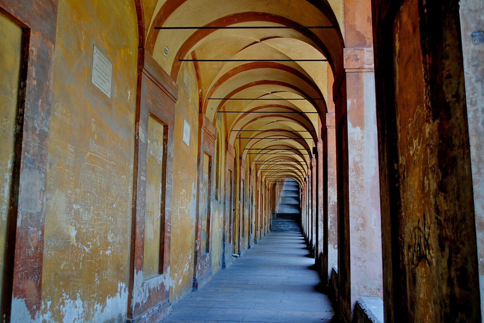 A stairway ascent beneath the arches of the Portico of San Luca
