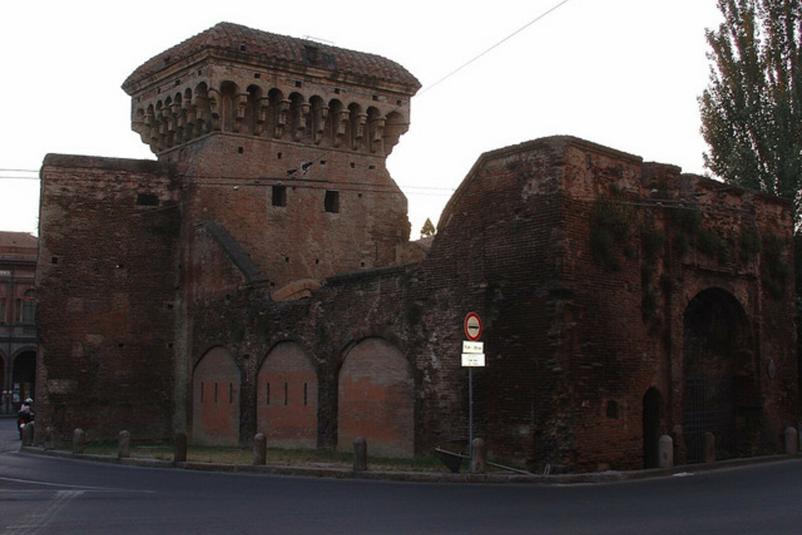 The brick arch of Porta San Donato with cyclists passing through