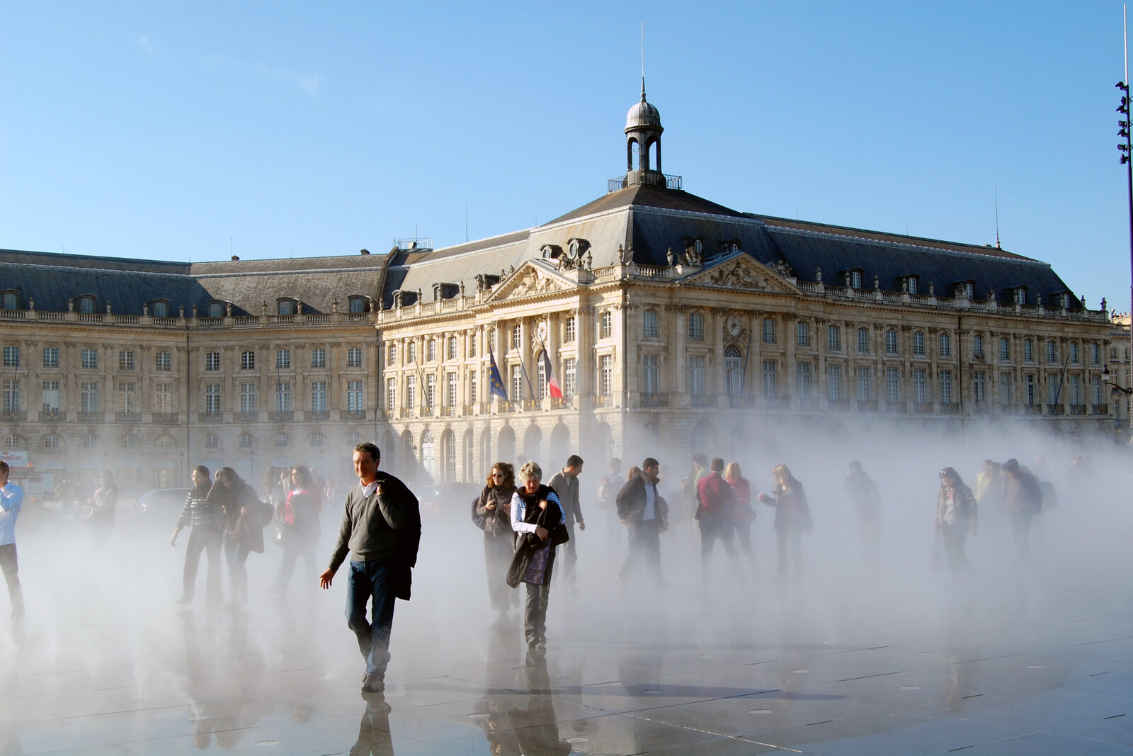 The water mirror at Place de la Bourse, reflecting the stone facades.