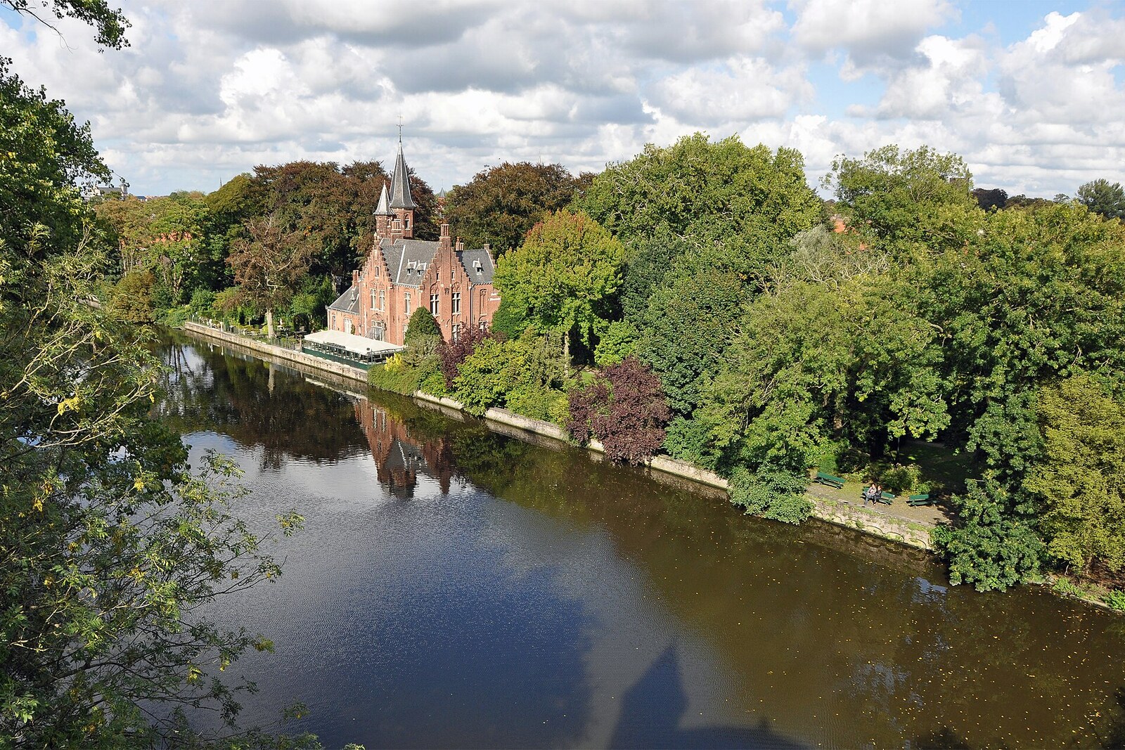Panorama des Minnewater im Minnewaterpark mit spiegelglattem Wasser und grünen Bäumen