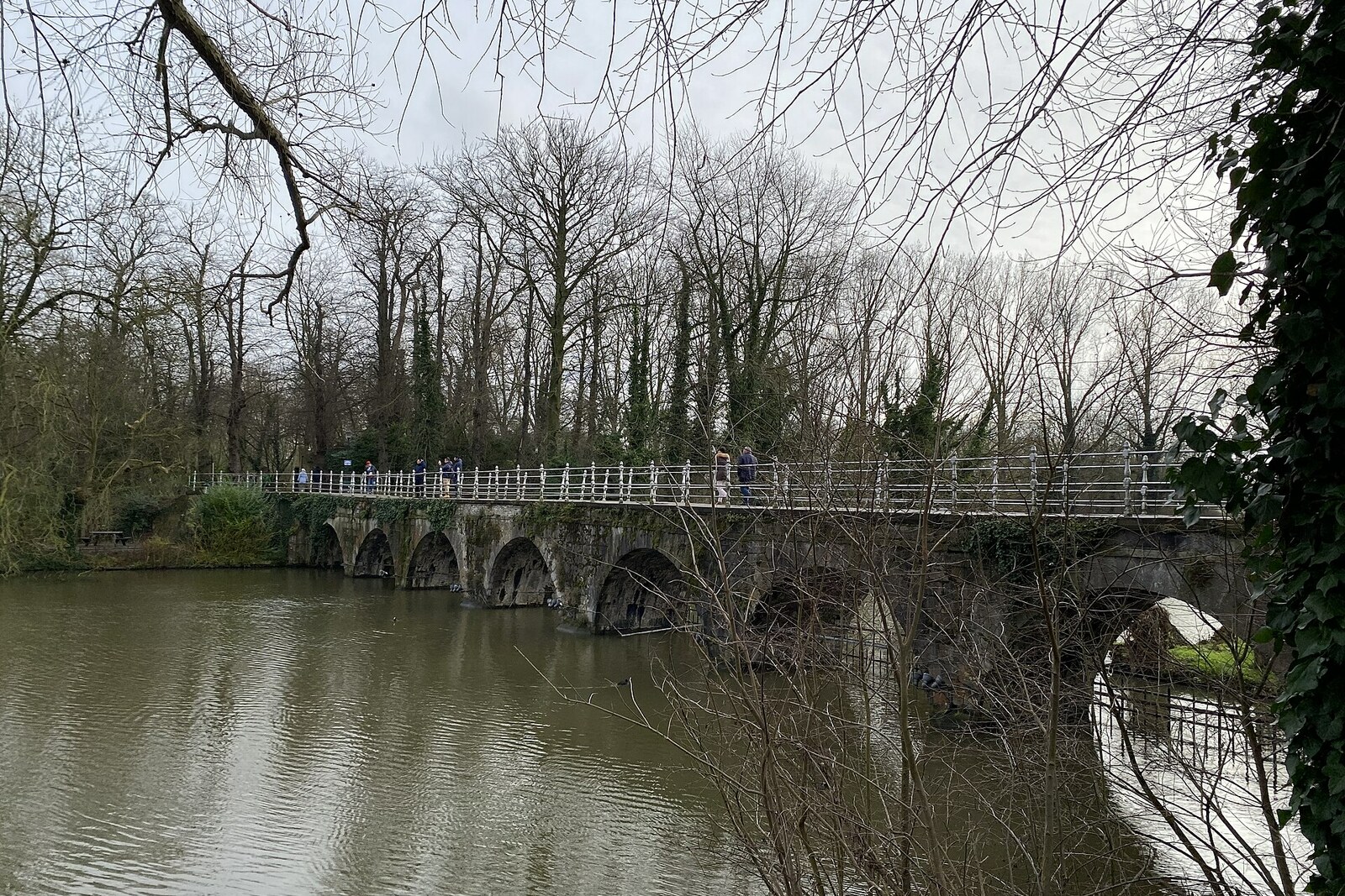 Brick Lovers' Bridge across the Lake of Love, reflected in the water with weeping willows