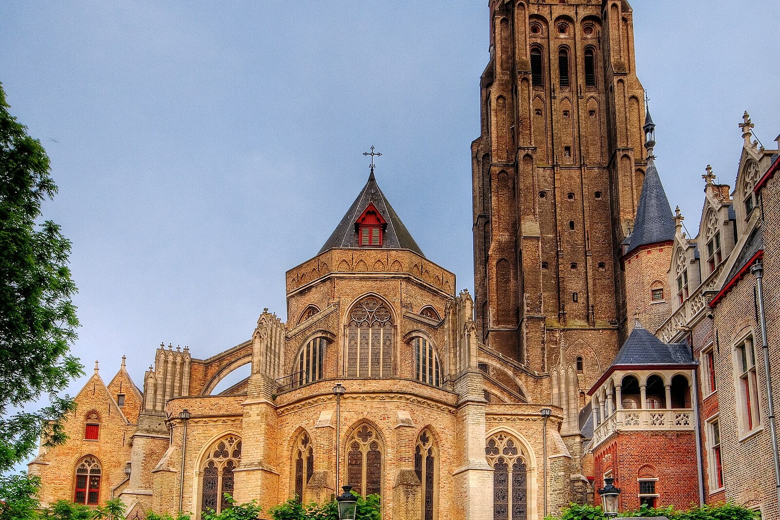 The tall brick spire and façade of the Church of Our Lady in Bruges.