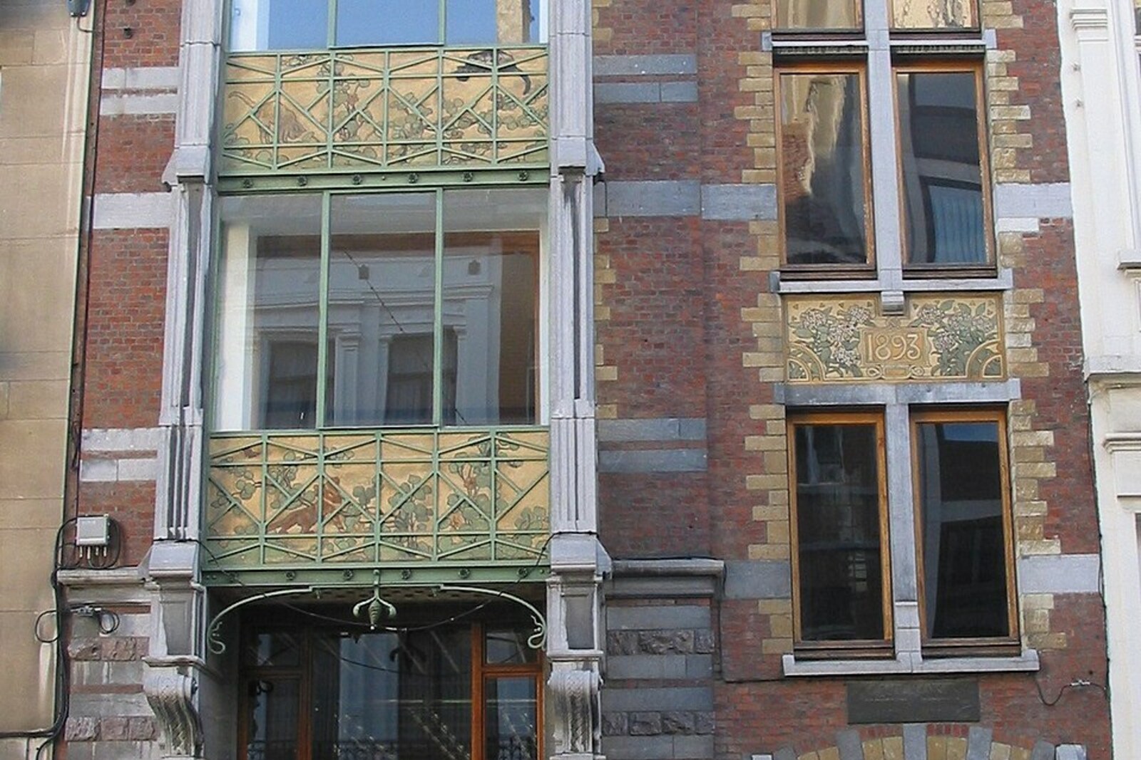 Maison Hankar with a brick facade, blue stone, and decorative panels.