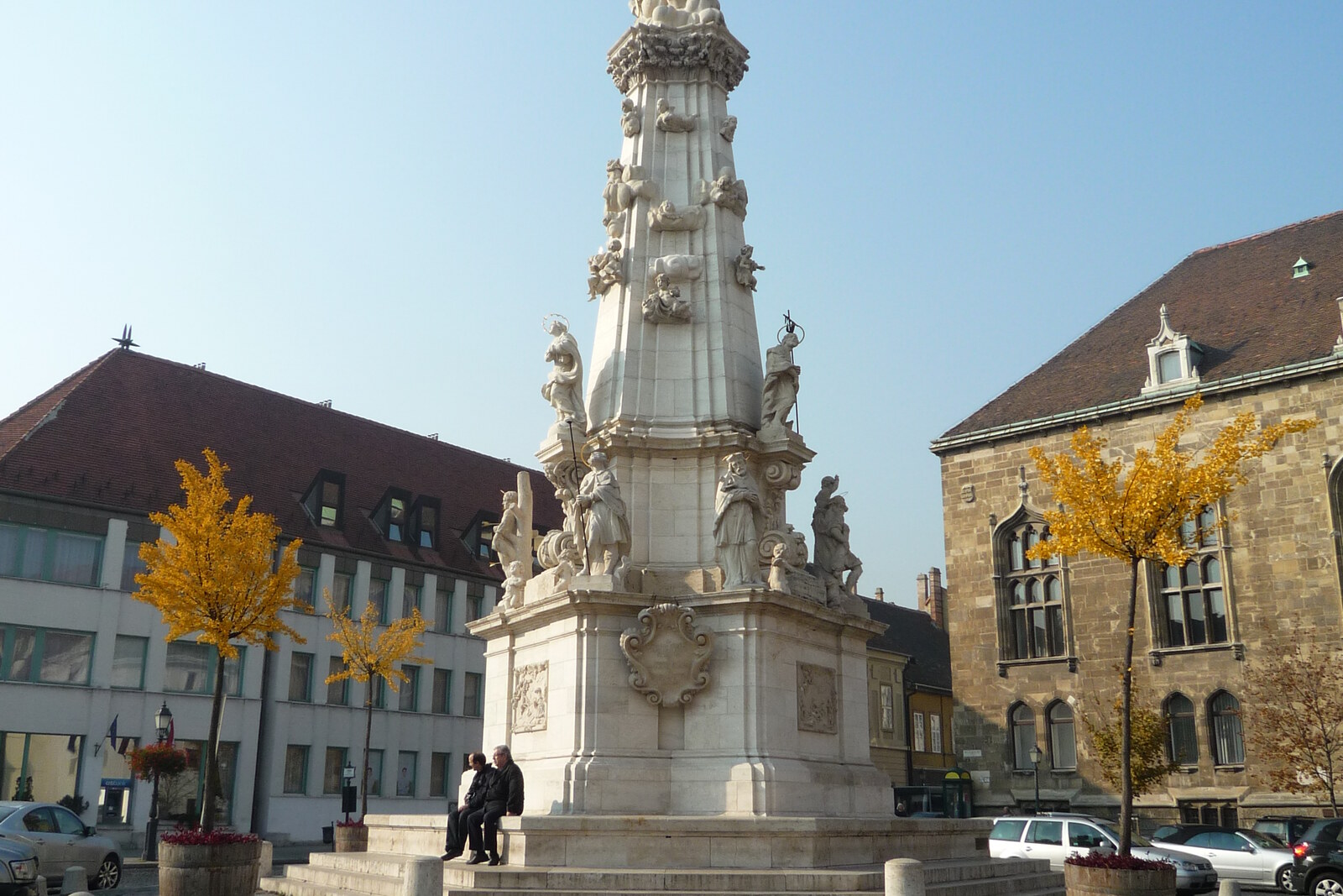 A white Baroque column of the Holy Trinity in an open square.