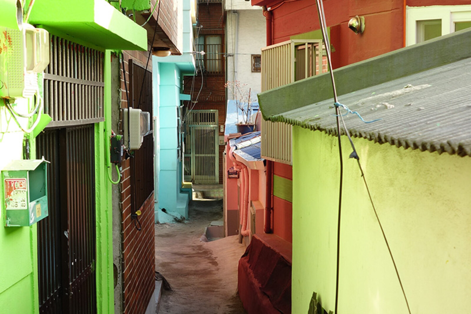 A narrow upper street in Gamcheon with houses, stairways, and private entrances.