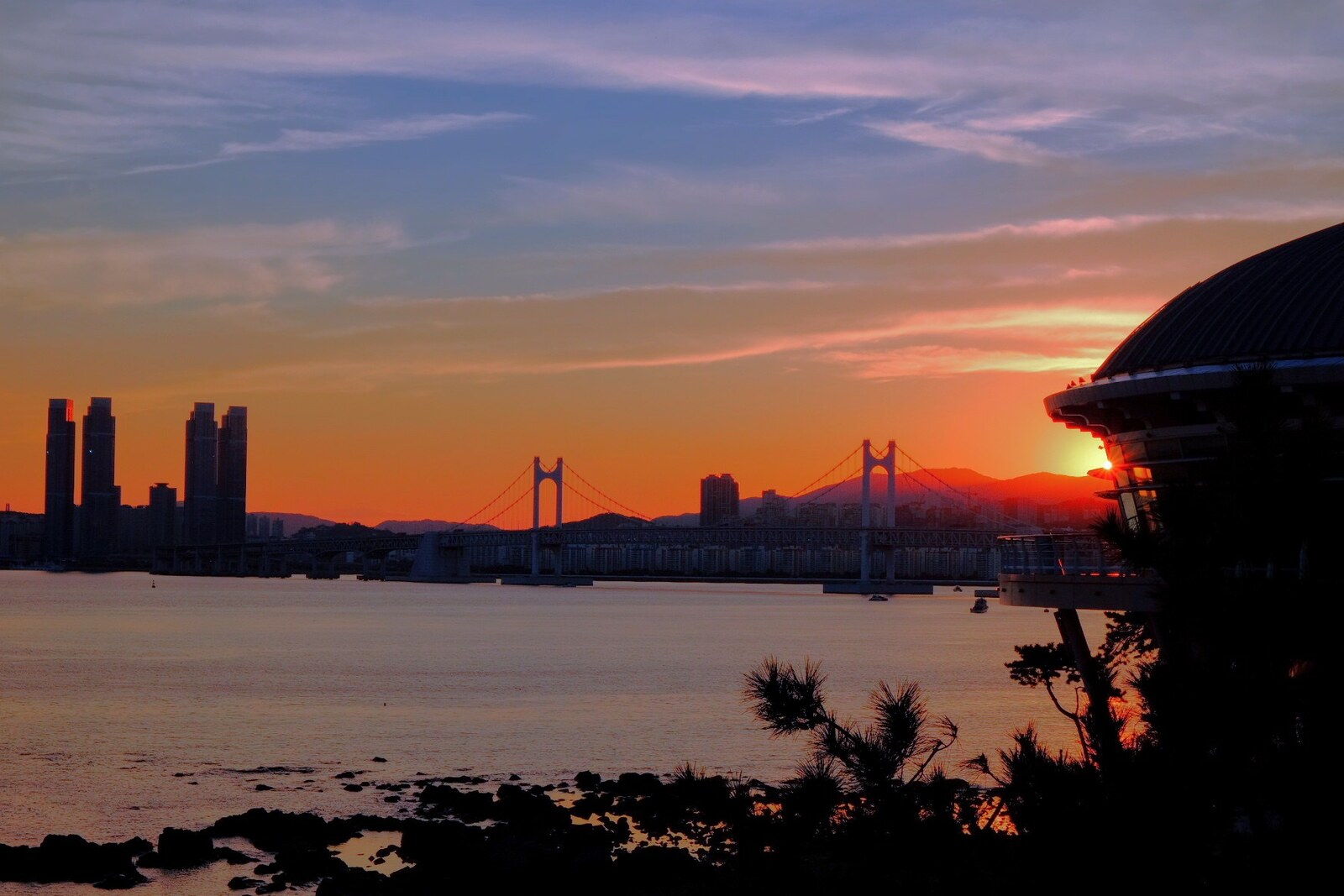 Dusk view from the Dongbaekseom Lighthouse of the Busan coast and the Nurimaru APEC House area.