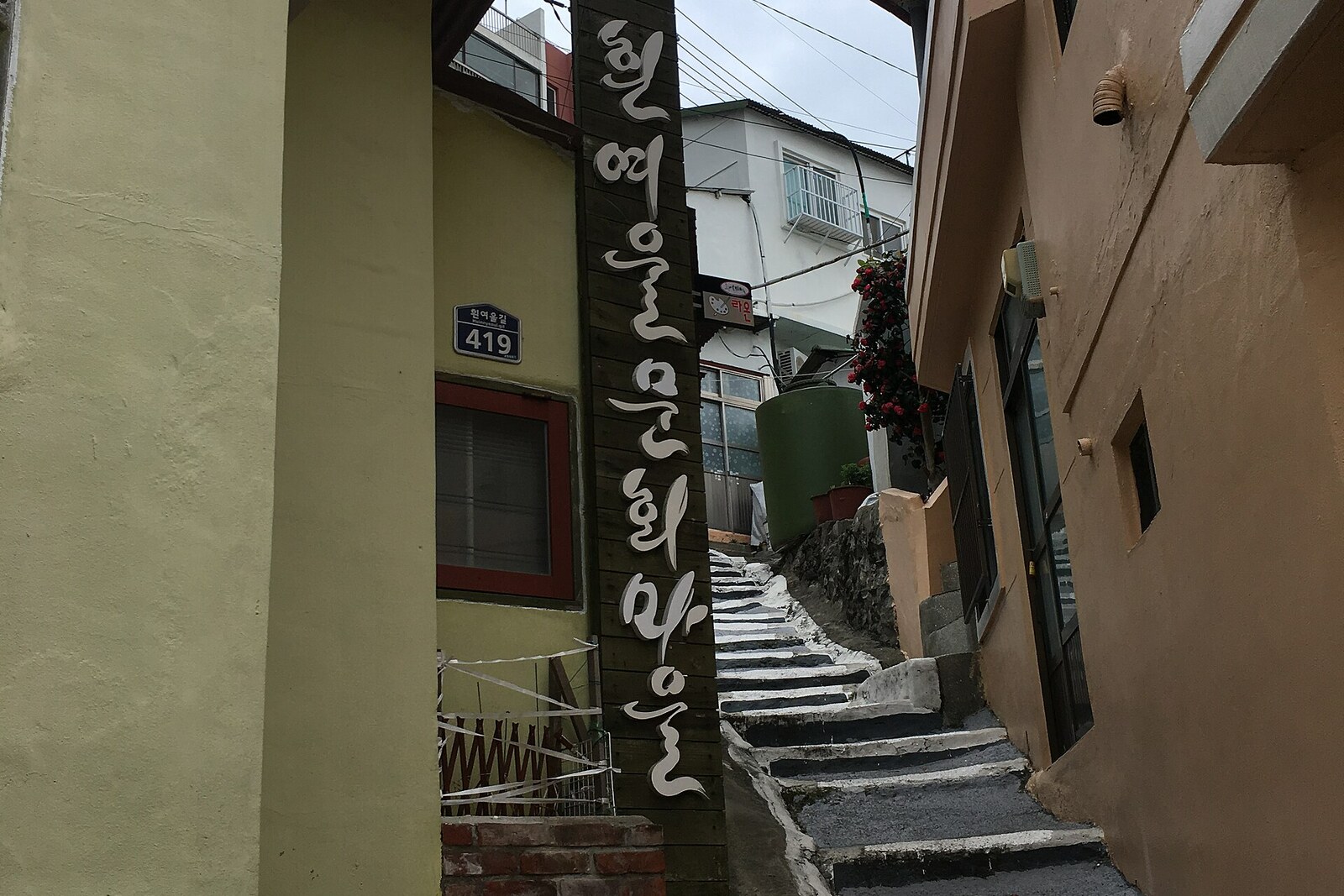 A narrow alley and a Huinnyeoul sign among the houses.