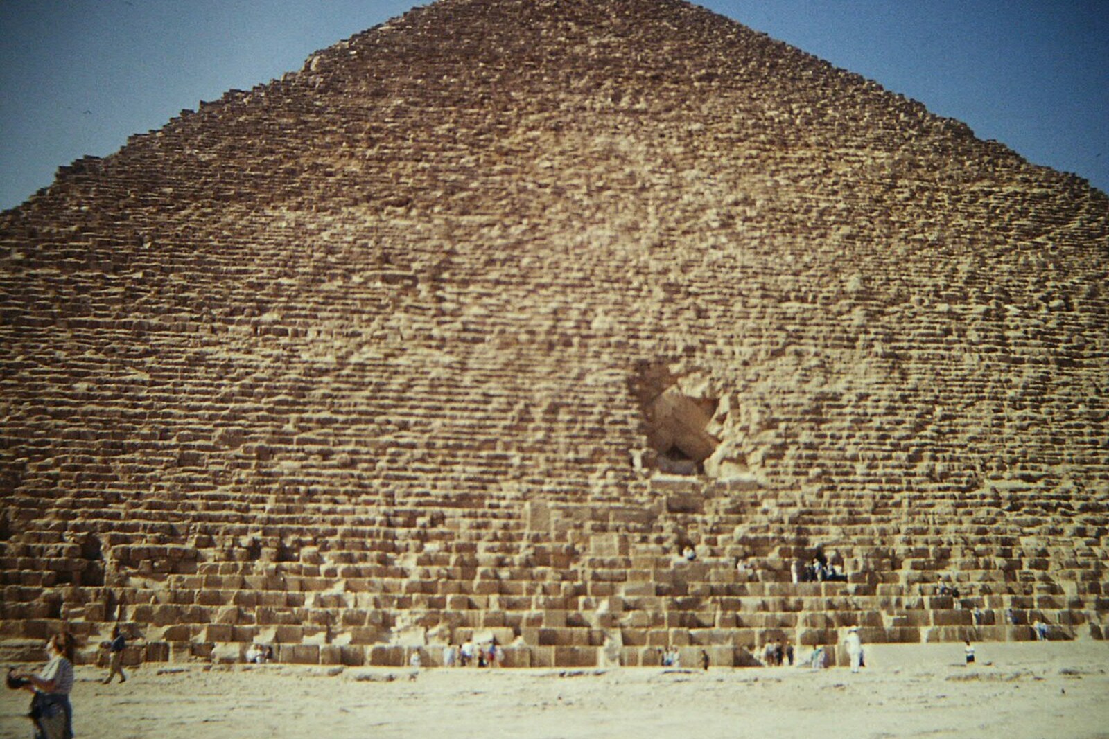 The Great Pyramid of Giza rises above a sandy plain.