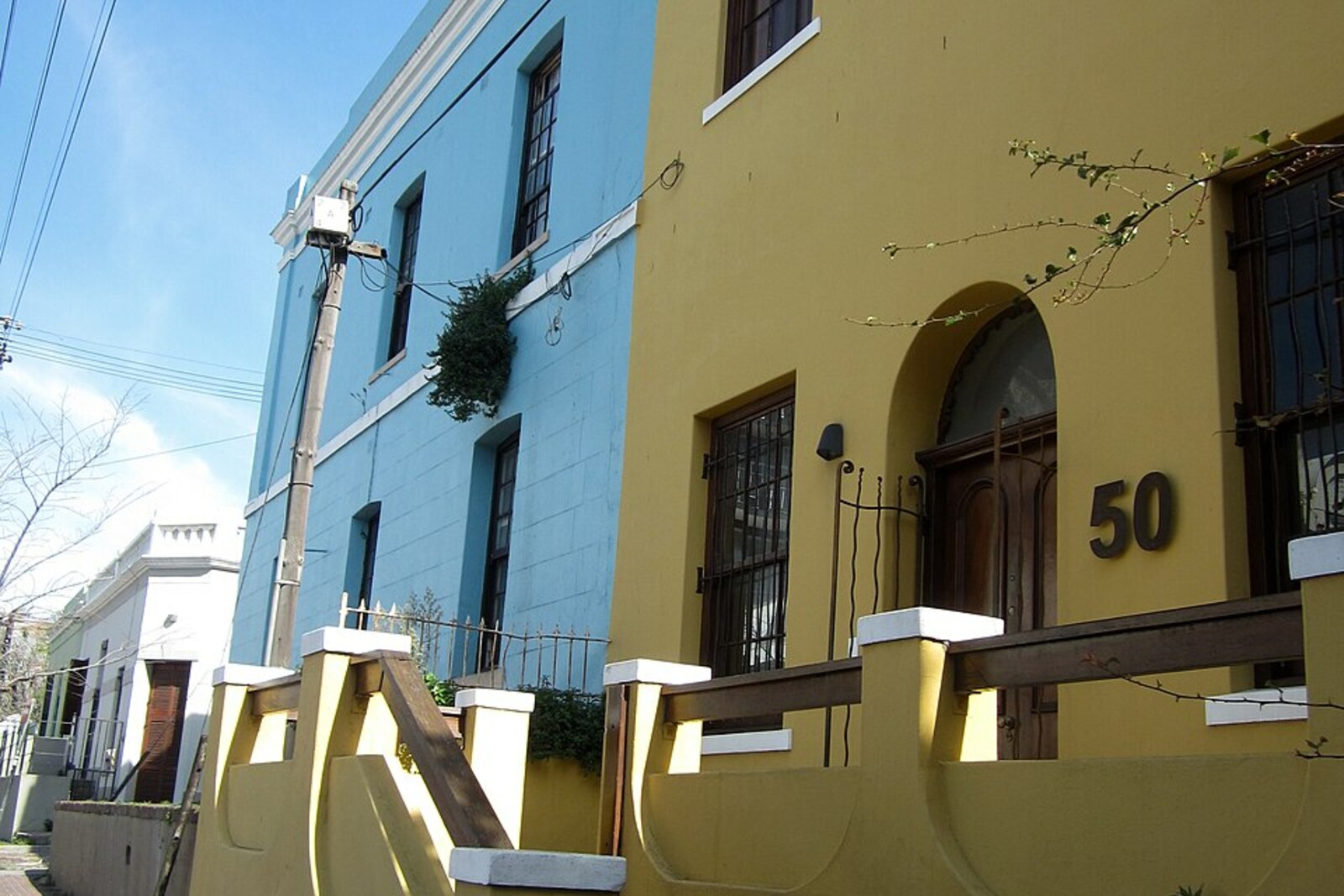 A house on Rose Street beside Bo-Kaap shops; the existing published photo asset is retained as neighborhood context, not as the exact facade of Atlas Trading.