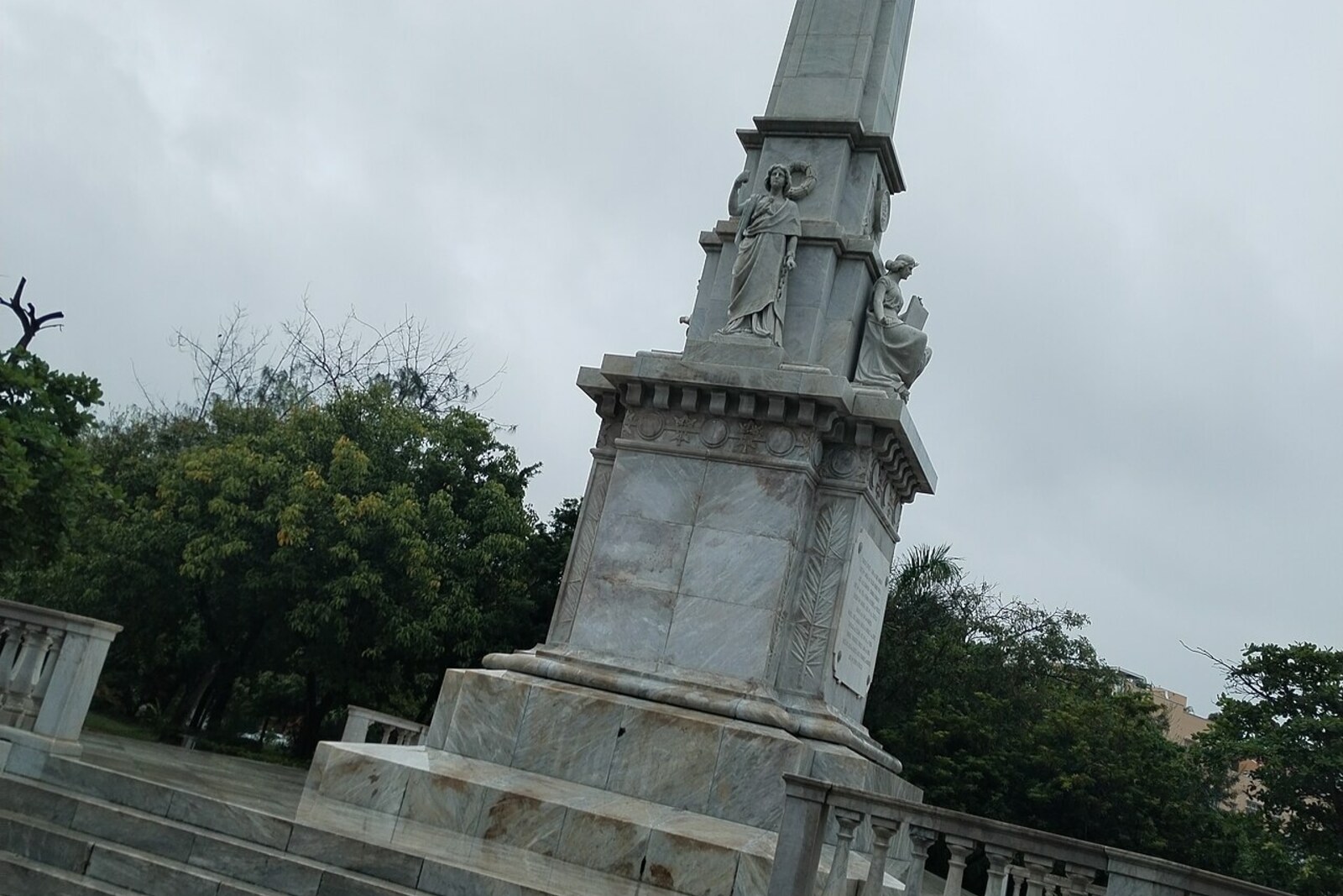A monument and fountain in Parque del Centenario surrounded by trees