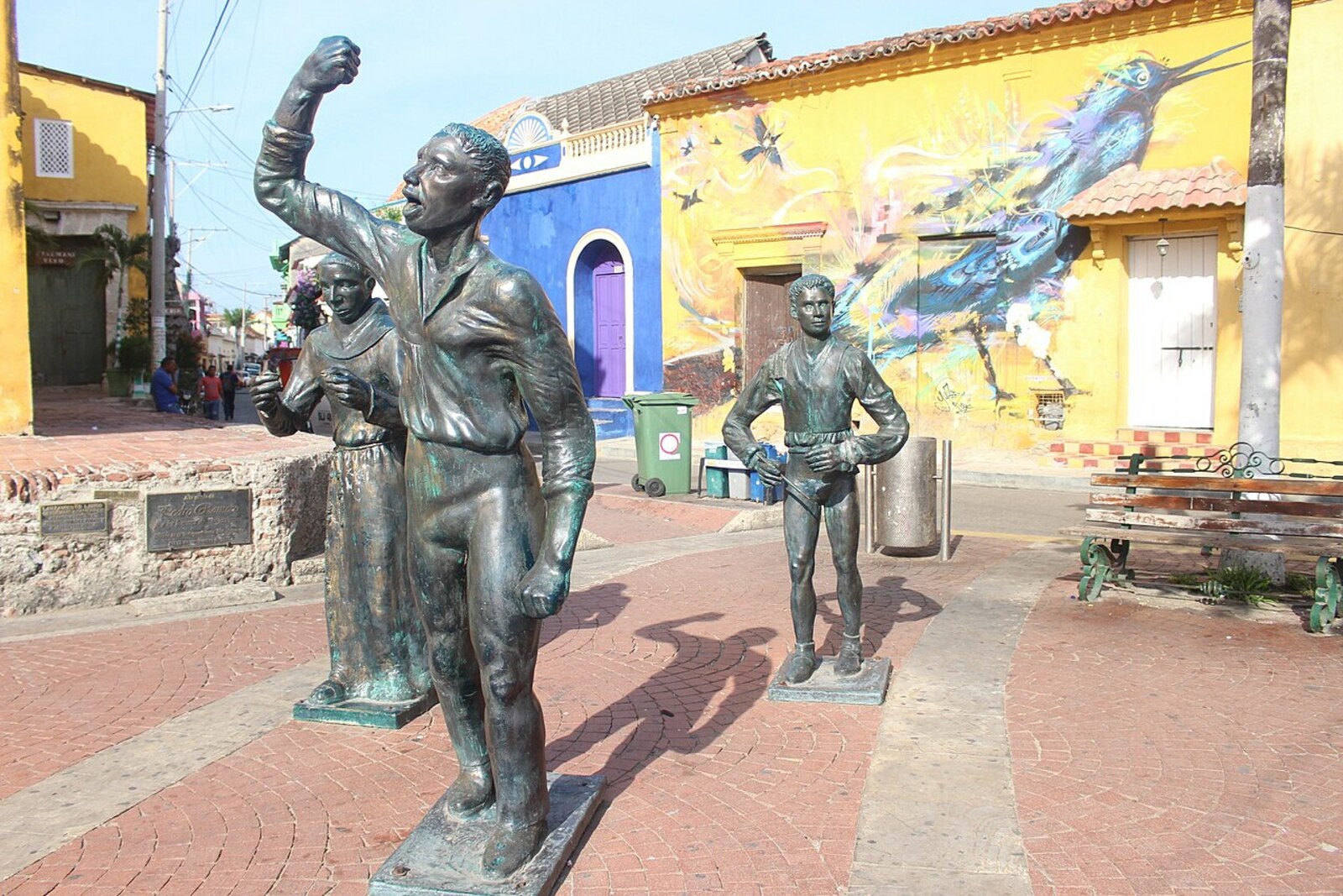 Bronze statues of Pedro Romero and a drummer on Plaza de la Trinidad in front of the yellow church