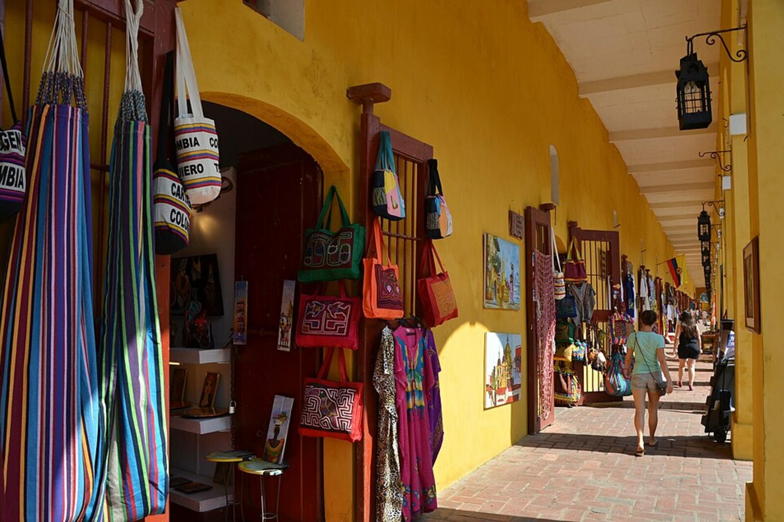 Las Bóvedas gallery in Cartagena, with yellow arches and souvenir shops.