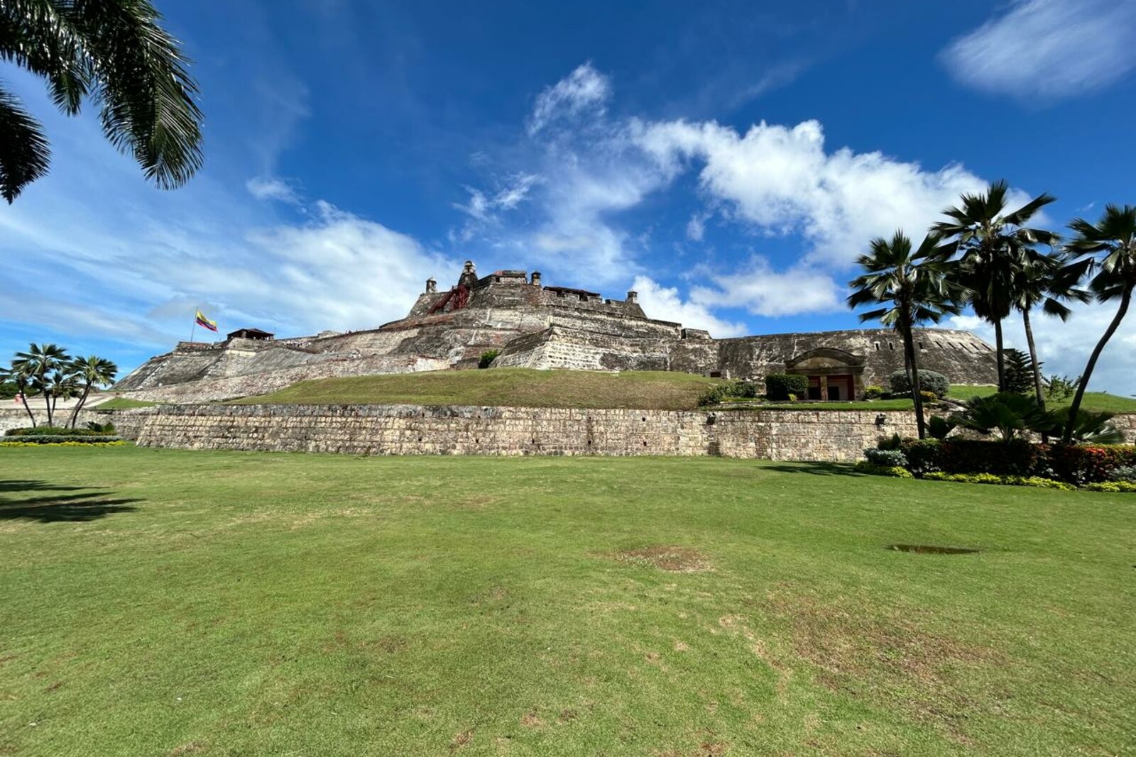 Green lawn and palm trees in front of the fortress of San Felipe de Barajas