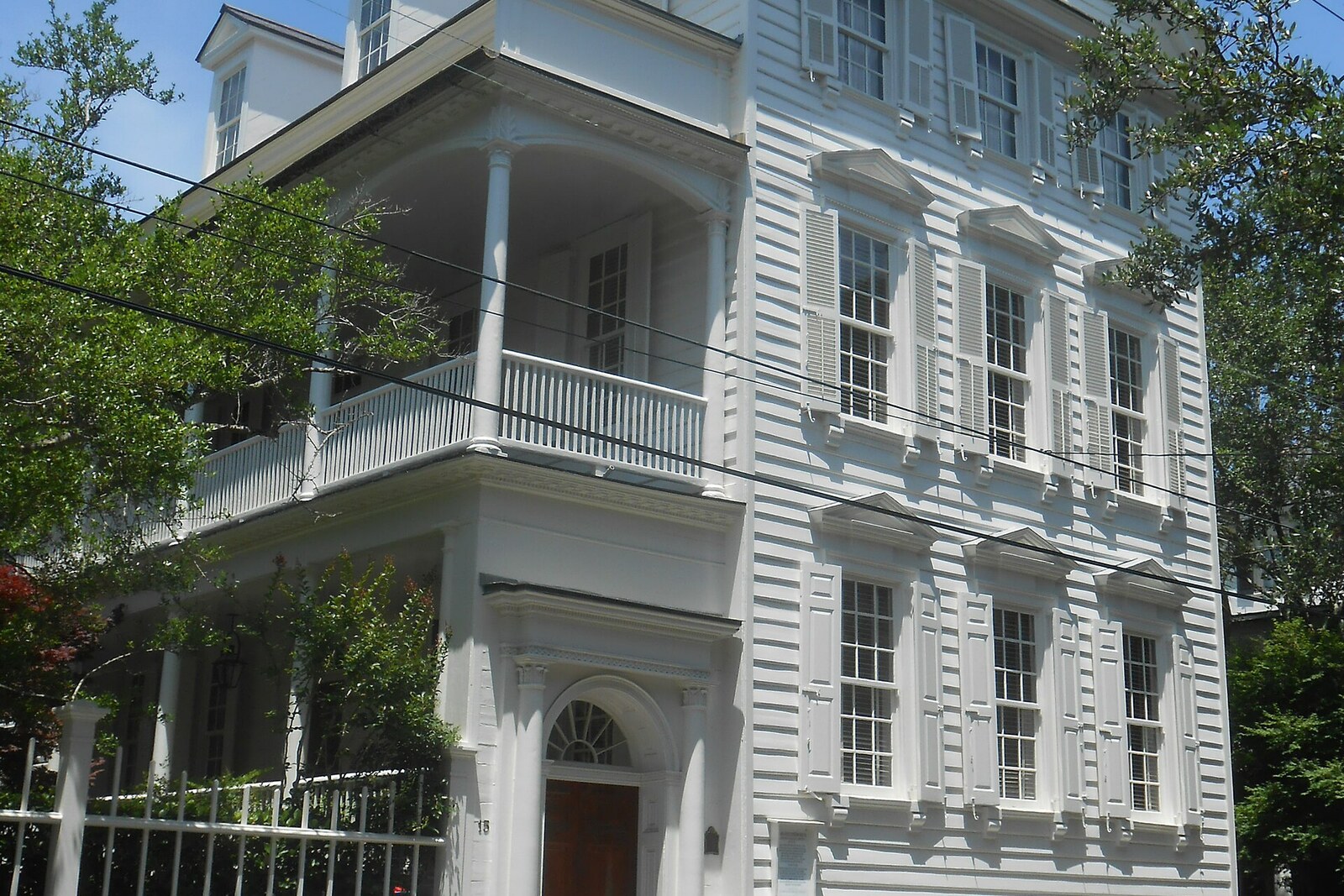 A house on Legare Street with a side piazza and a fence.