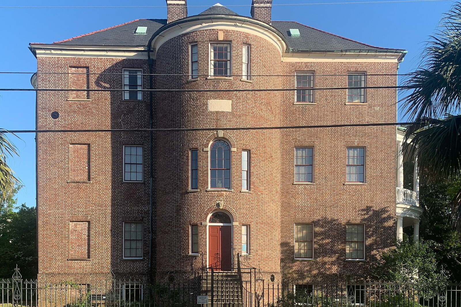 Joseph Manigault House with a brick façade, portico, and green shutters.