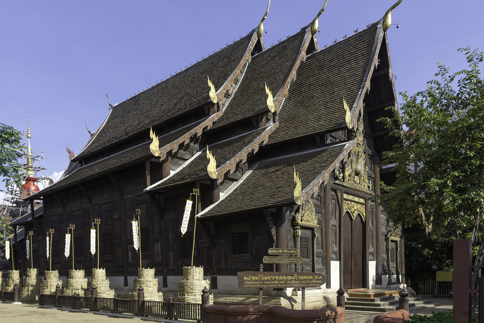 The teak viharn of Wat Phan Tao, with dark wood carvings and a tiered roof.