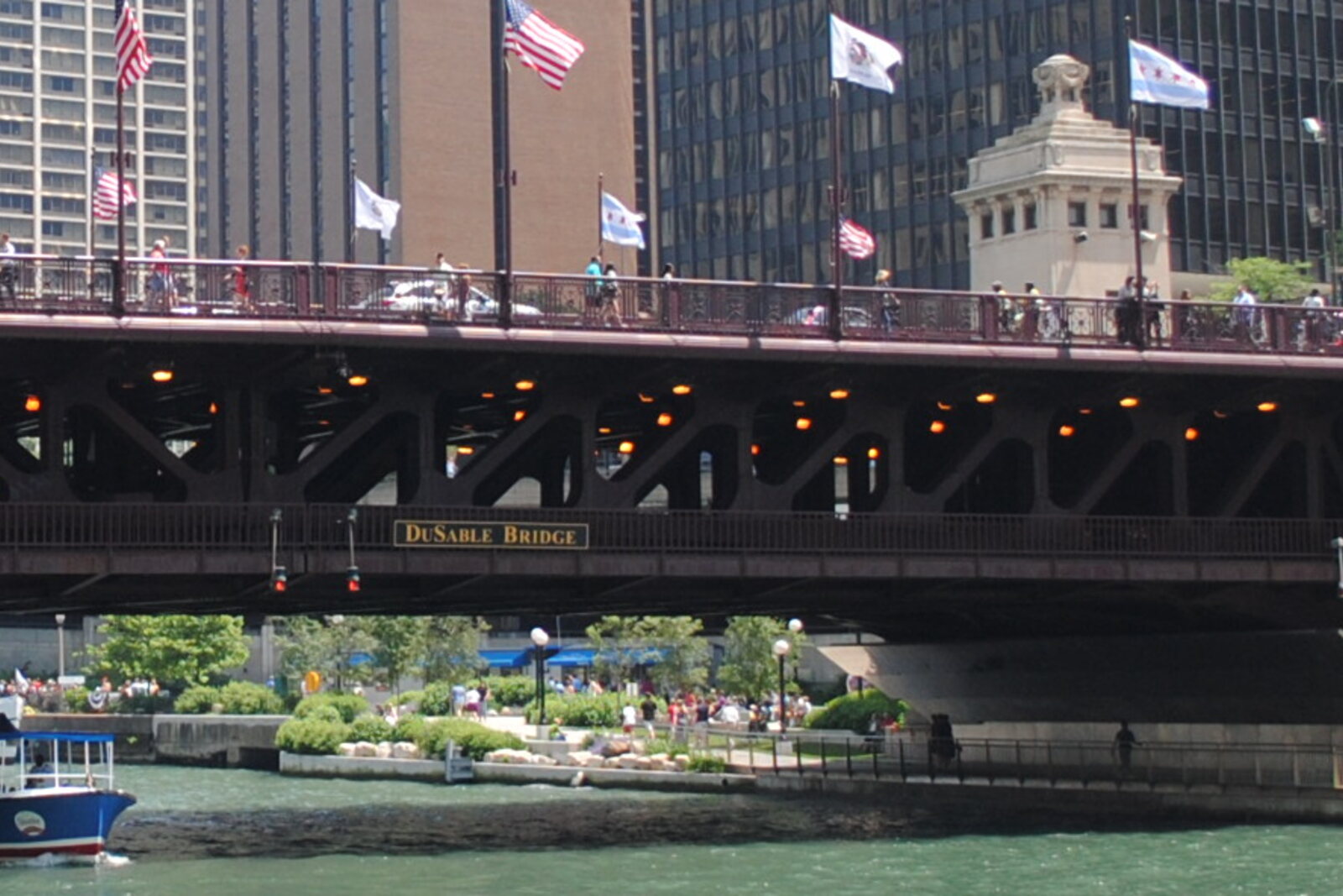 The lower level of the river promenade with water, steps, and bridges.