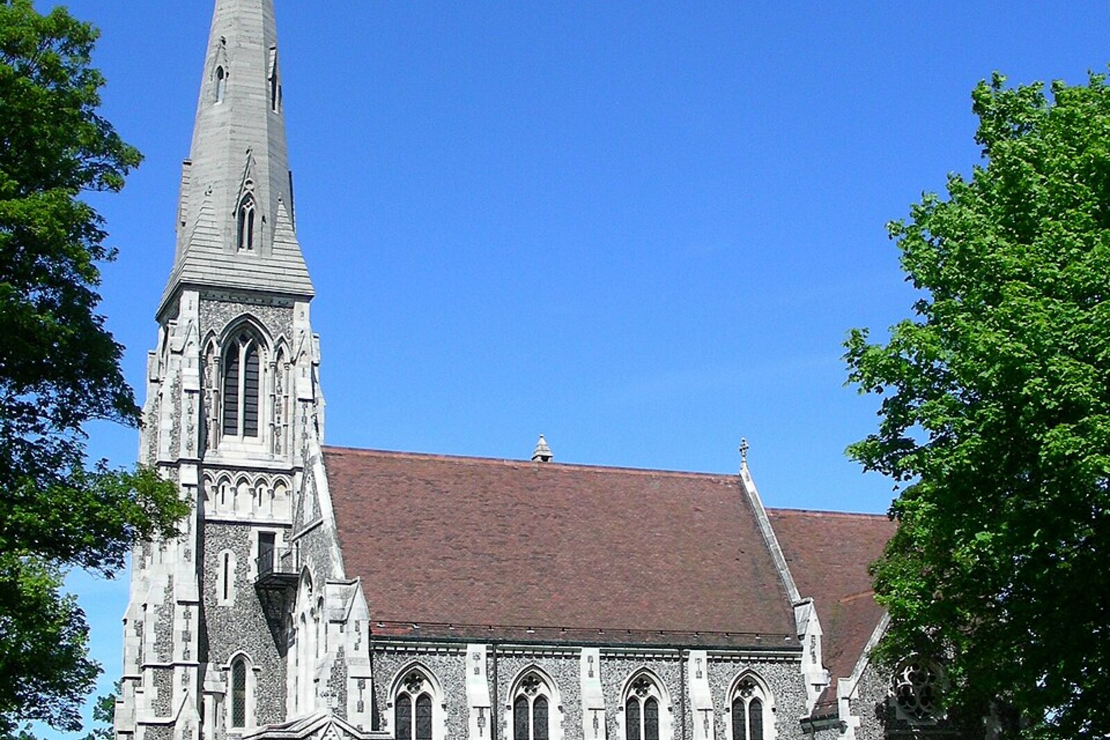 St Alban's Church with flint walls and a tall spire