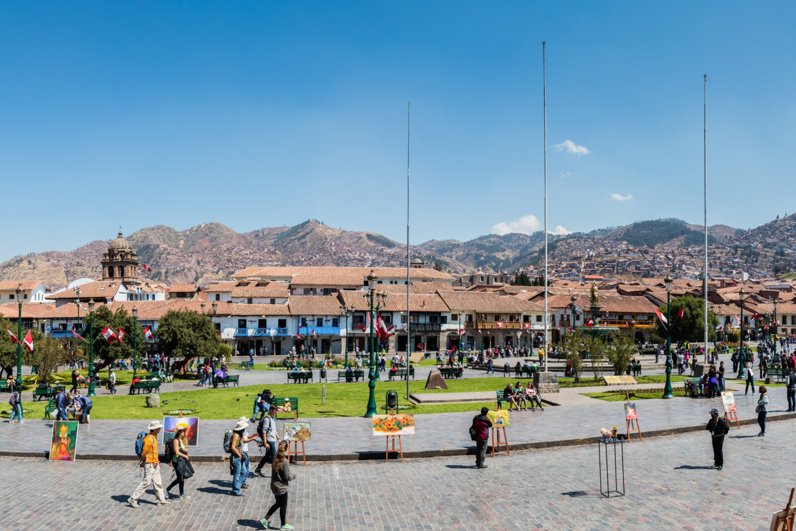 Panoramic view of Plaza de Armas in Cusco with gardens, arcades, and a mountain backdrop