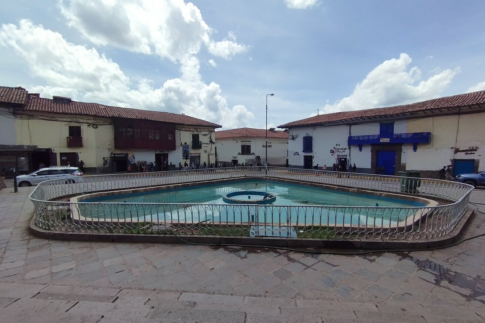 The fountain of Plaza San Francisco in Cusco, with colonial buildings in the background.