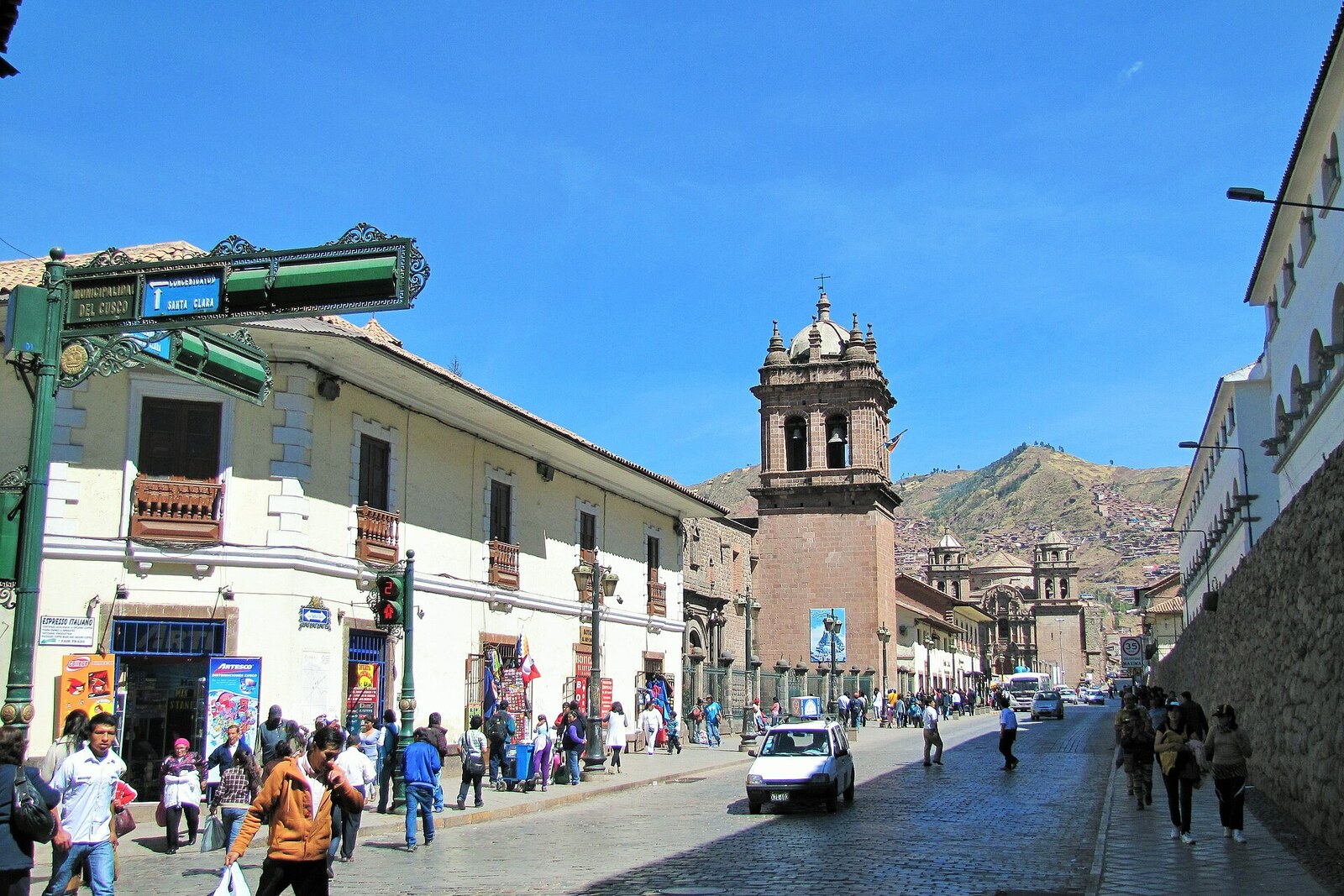 A narrow Calle Santa Clara in Cusco with shops and signs.
