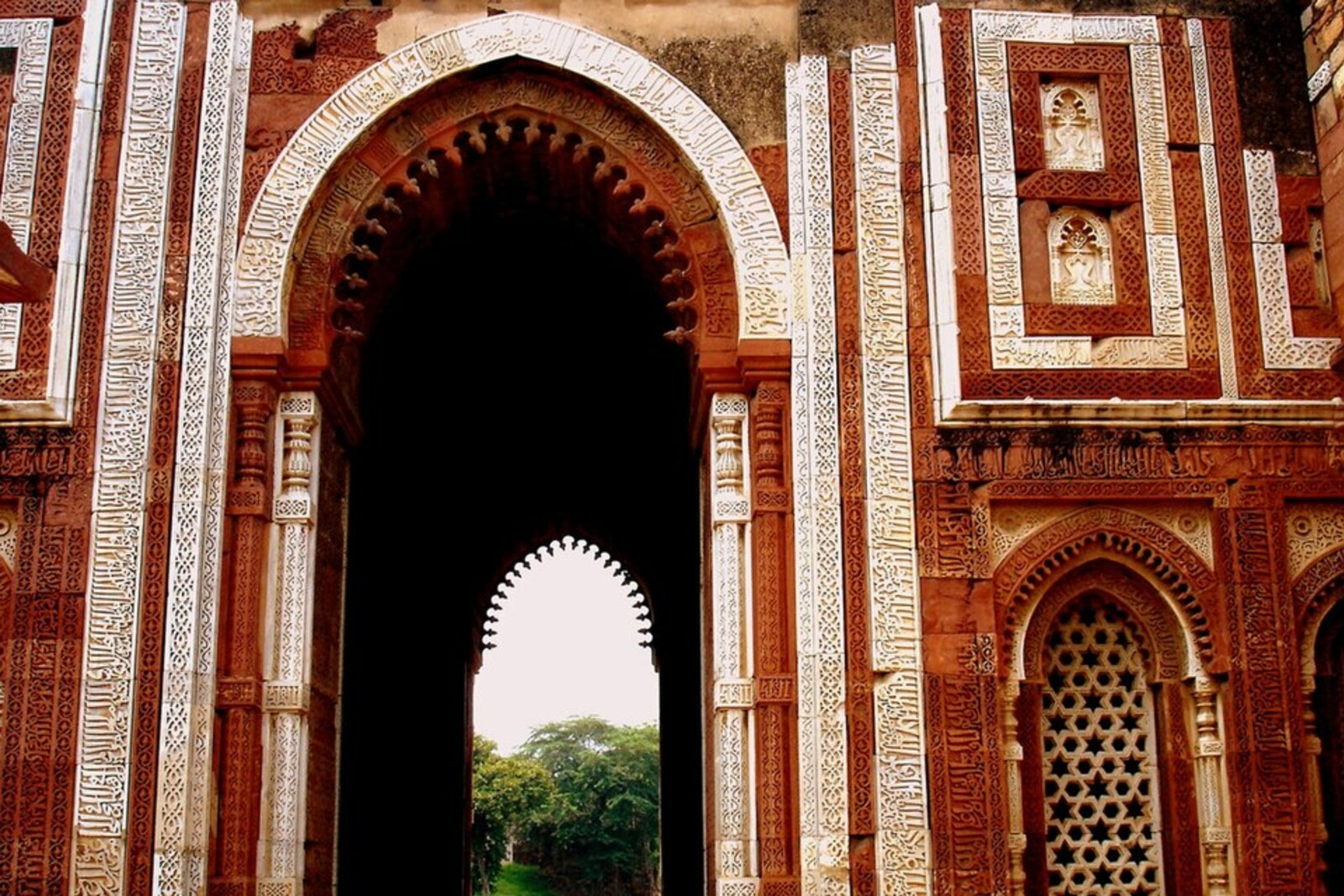 Alâi Darwaza en grès rouge, avec des incrustations blanches et des arcs sculptés.