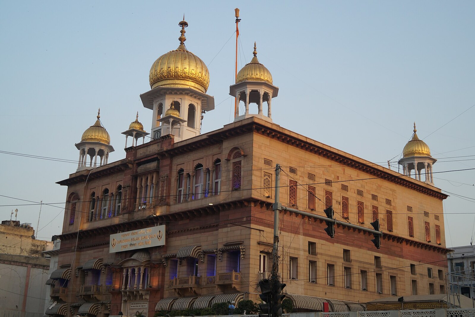 The facade and golden domes of Gurdwara Sis Ganj Sahib.