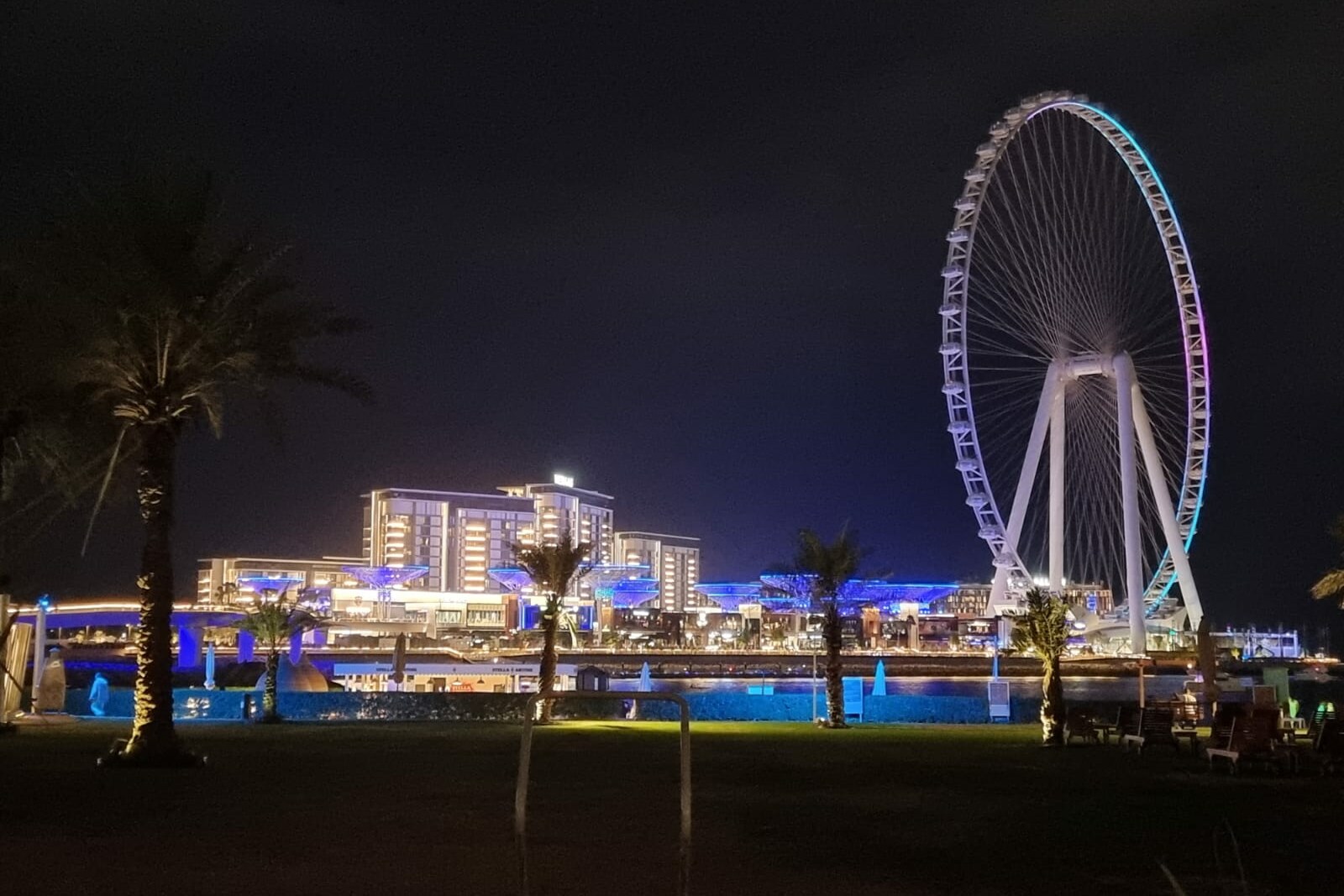 Ain Dubai am Abend, von bunten Lichtern beleuchtet.