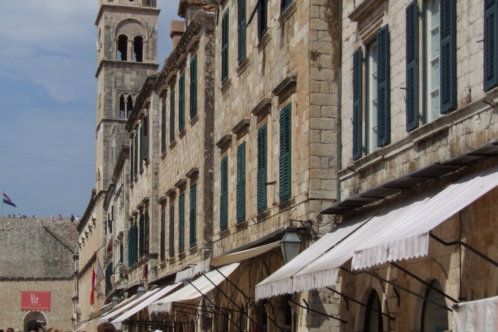 Stradun in Dubrovnik, with stone facades and a bell tower along the main street.