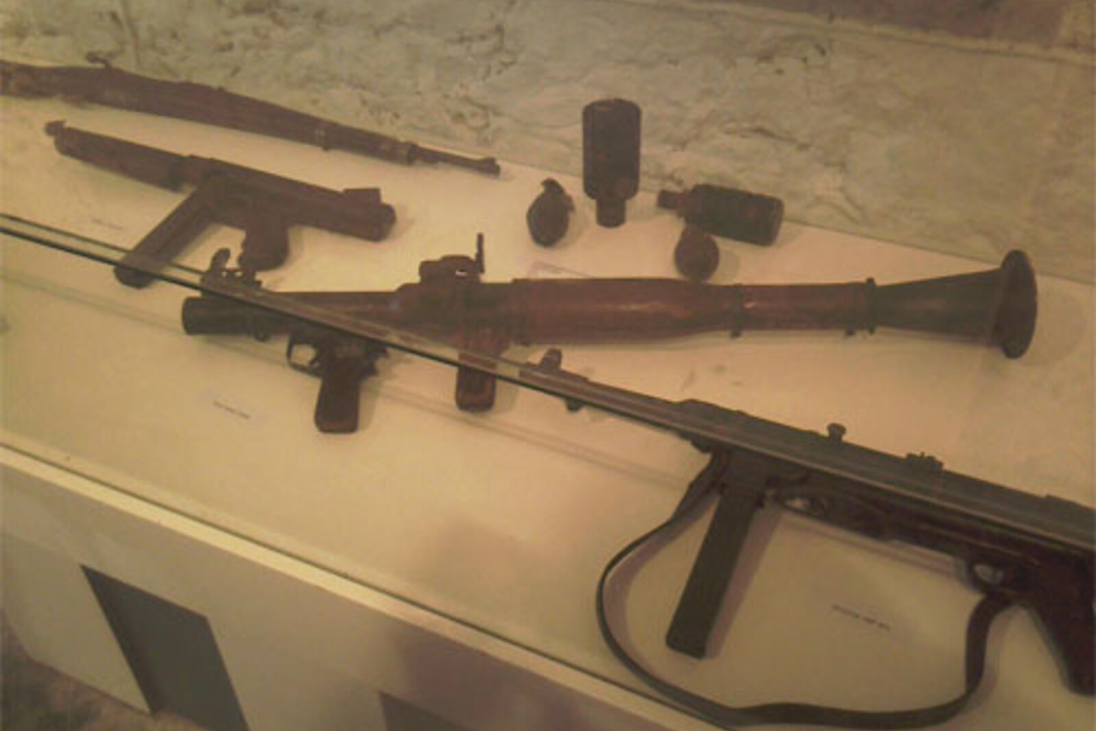Museum exhibition in Fort Imperial: displays, weapons, and photographs on stone walls