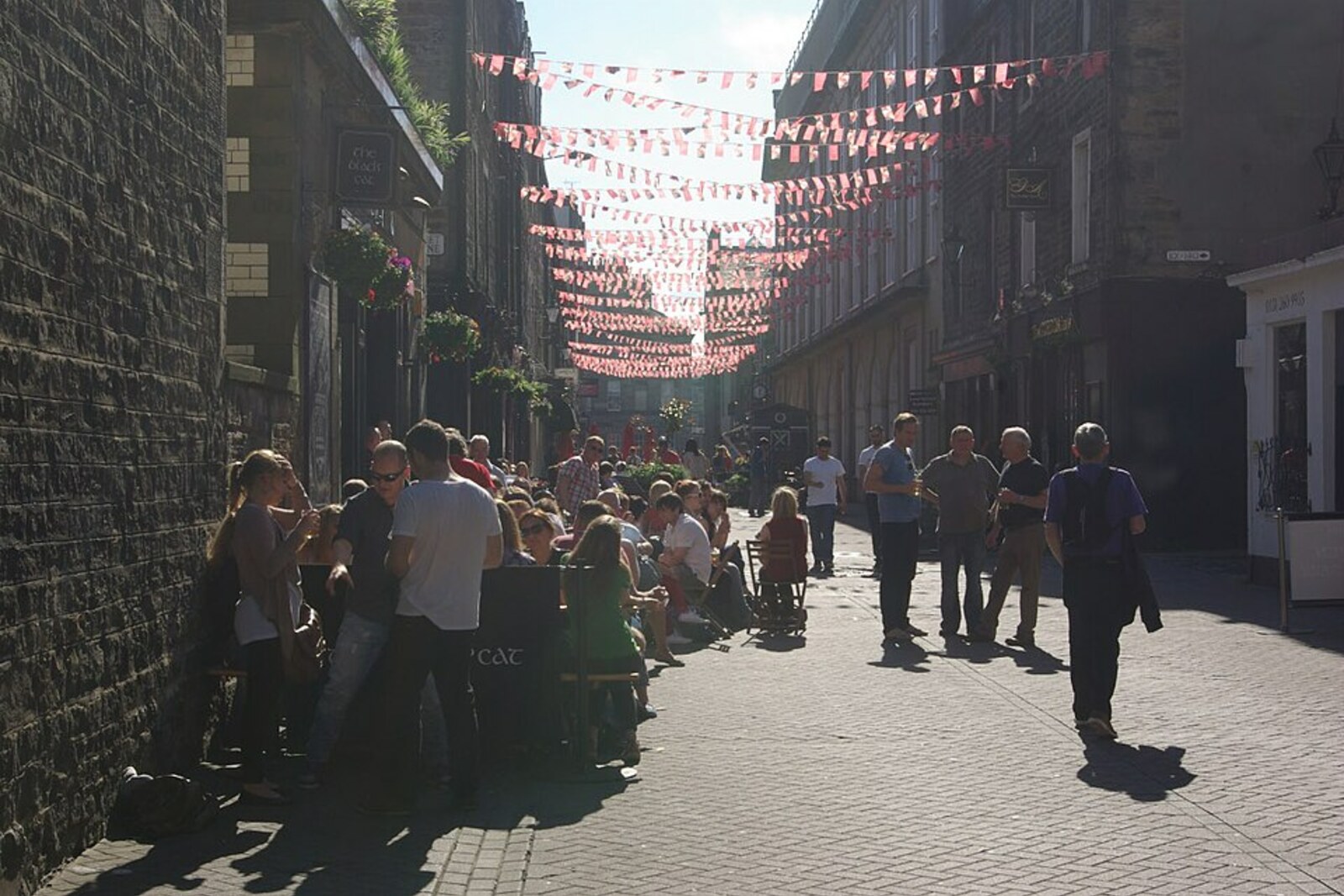 The narrow lane of Rose Street, with small buildings and shop signs along both sides.