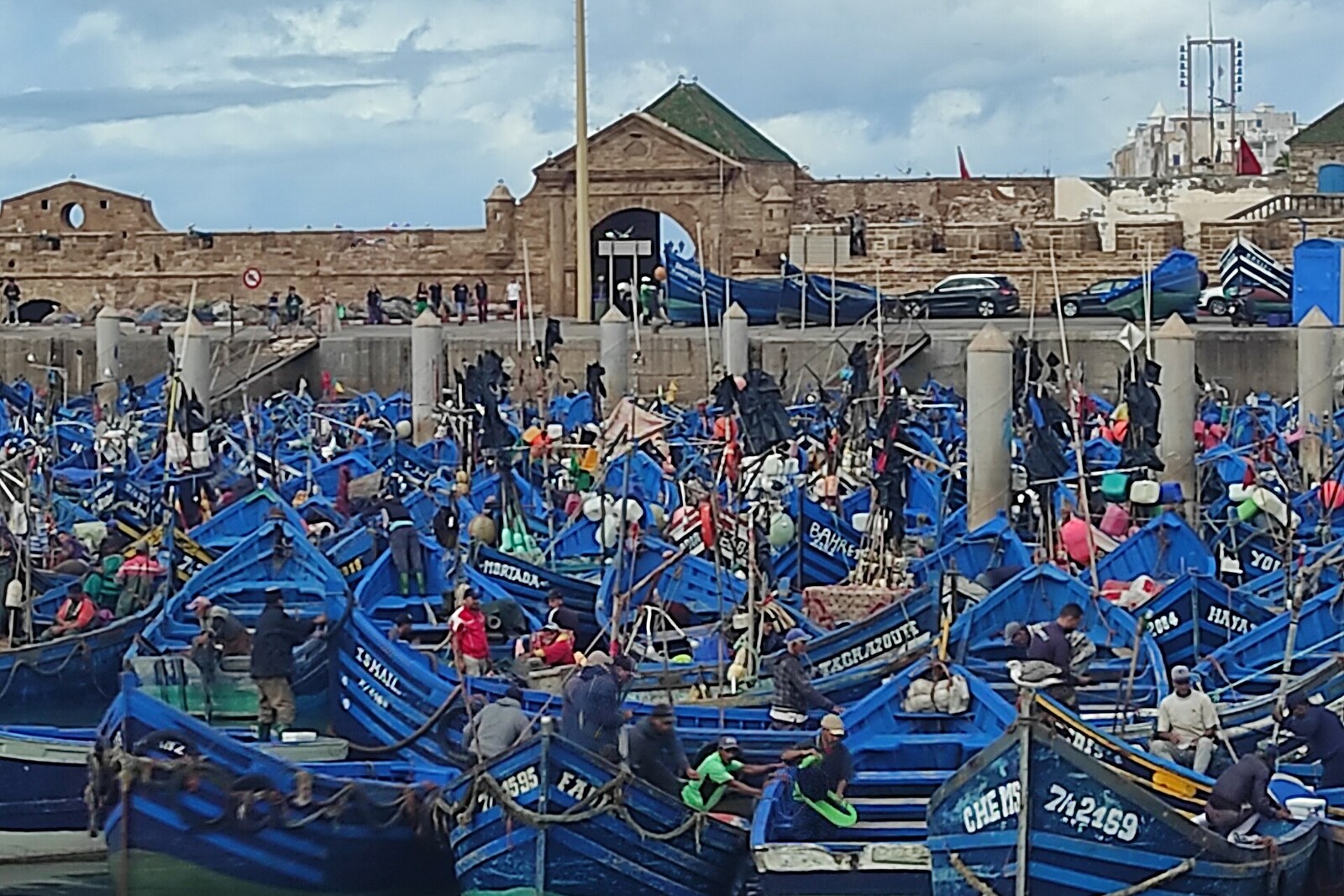 Blue fishing boats in Essaouira's working harbor.