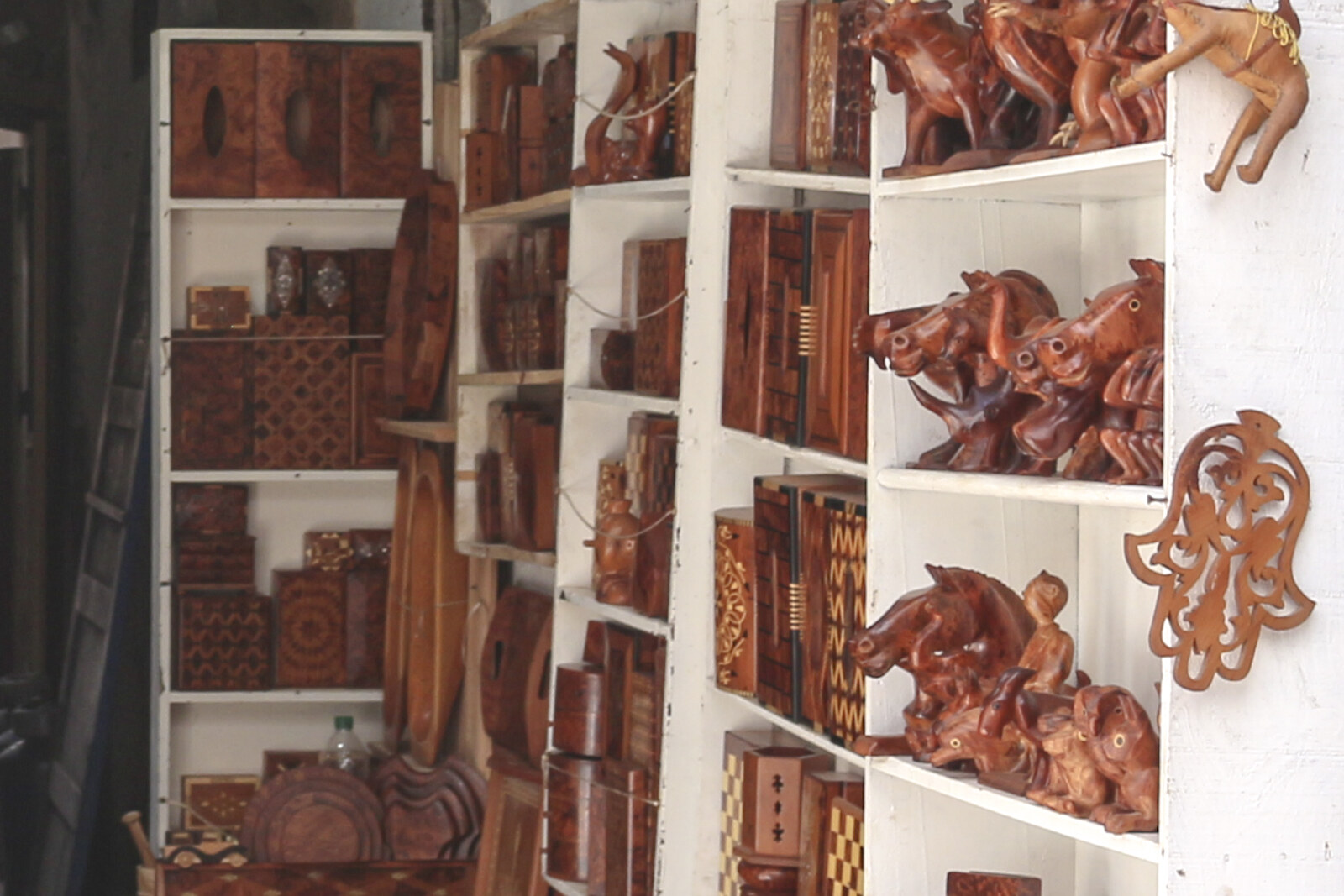 Shelves of polished wooden objects in an Essaouira workshop.