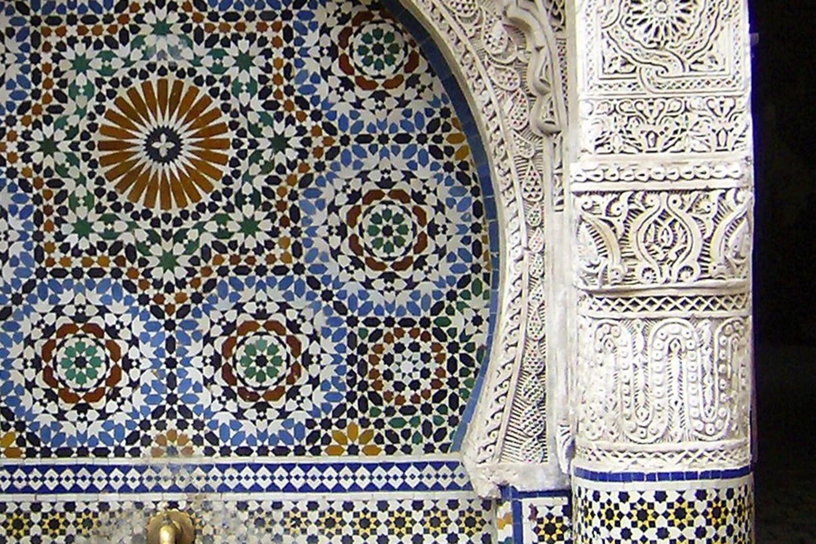 The tiled Nejjarine Fountain with a carved white arch and blue inlays.