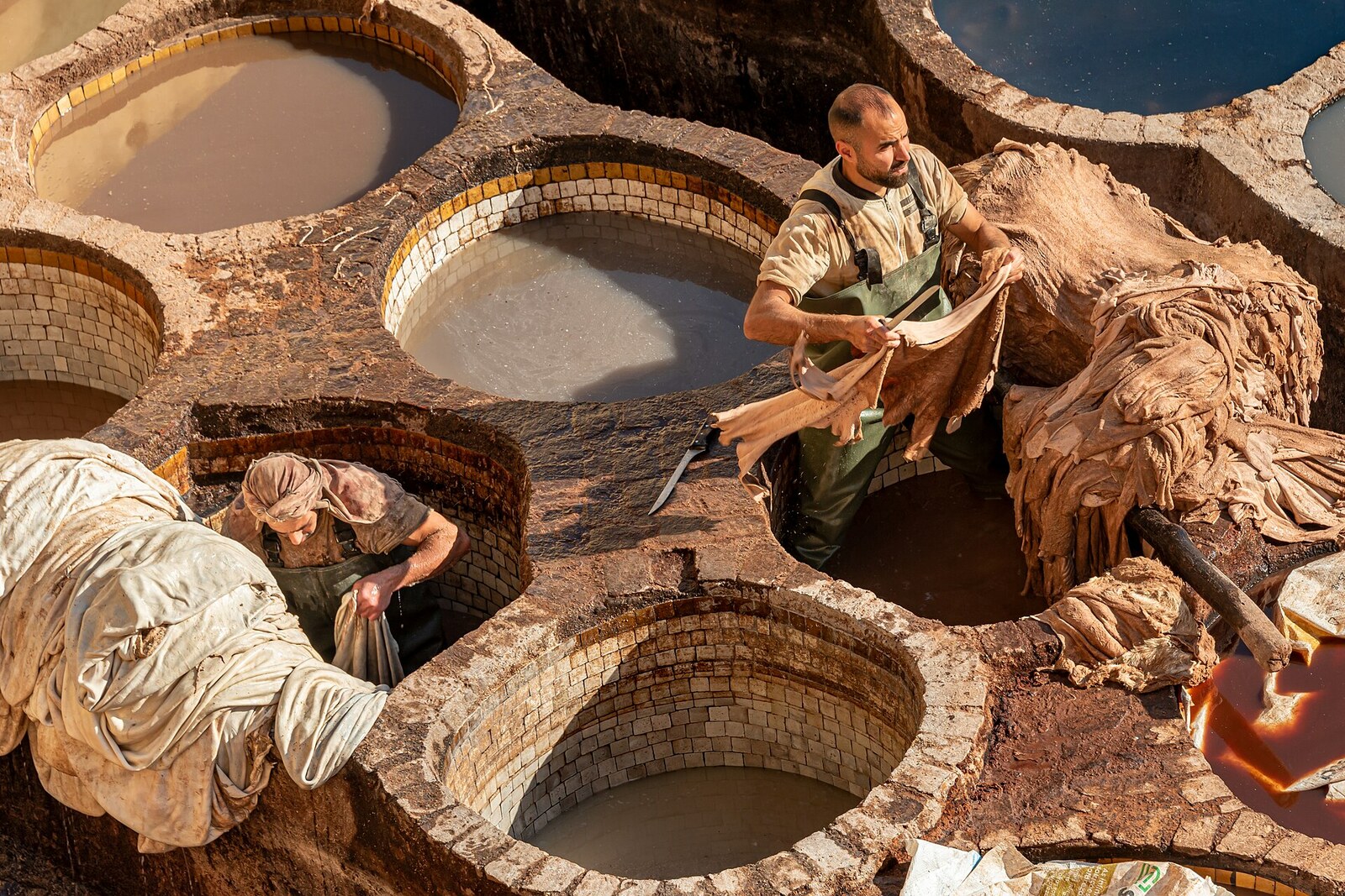 Overhead view of hundreds of round vats with bright dyes and workers at Chouara Tannery