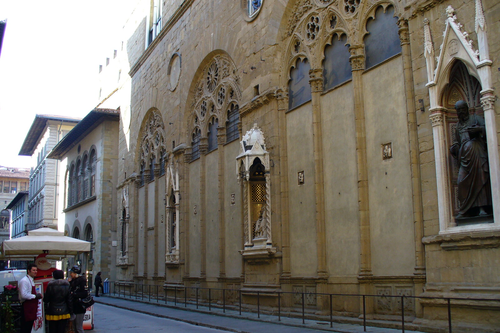 The facade of Orsanmichele along a narrow street in Florence.