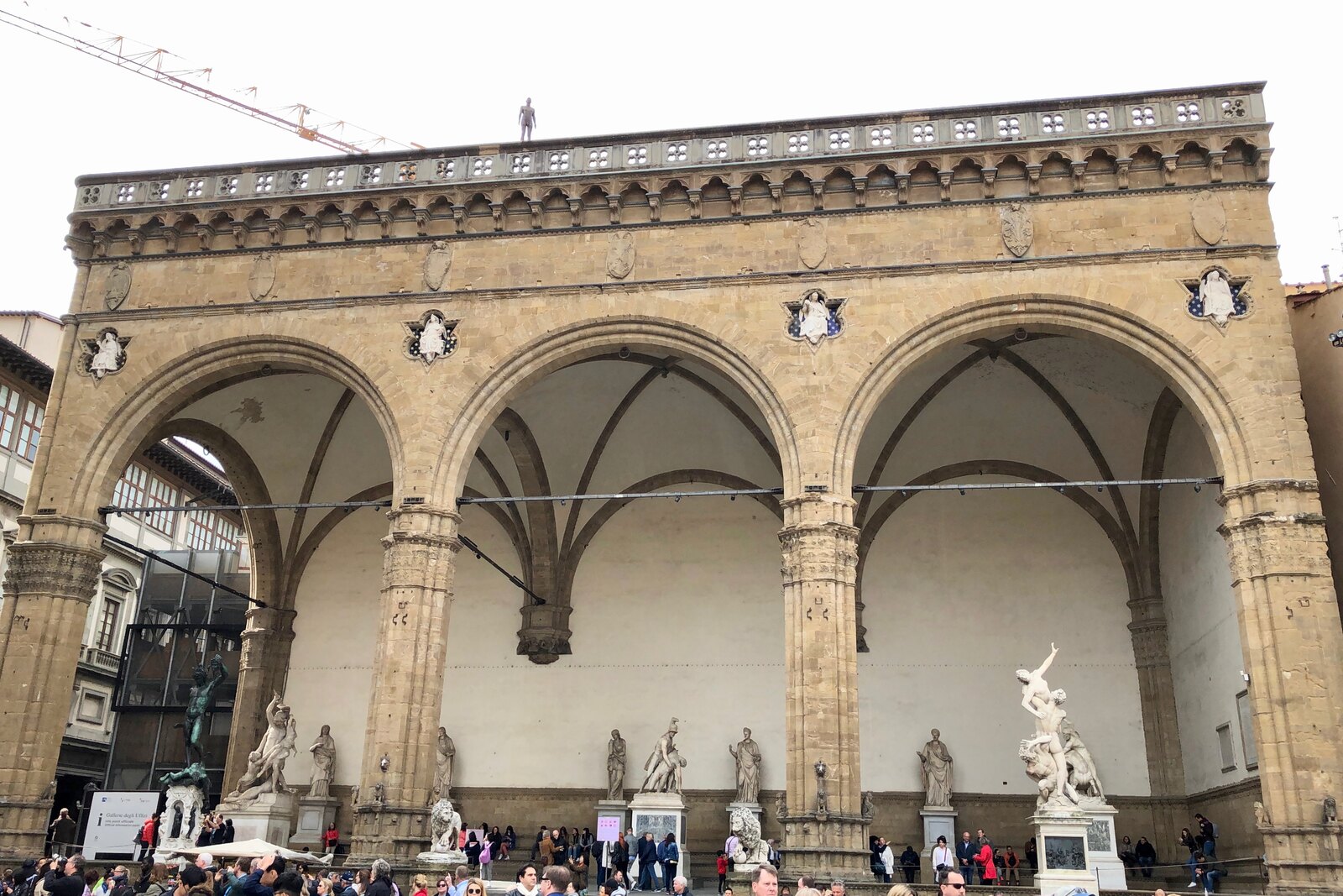 Loggia dei Lanzi with three large arches and sculptures in the square.