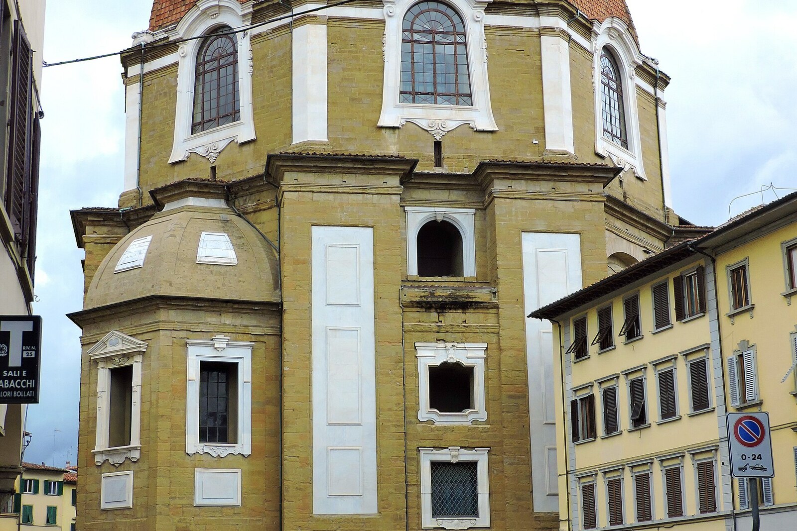 The large domed hall of the Medici Chapels, surrounded by brick walls and a dome.
