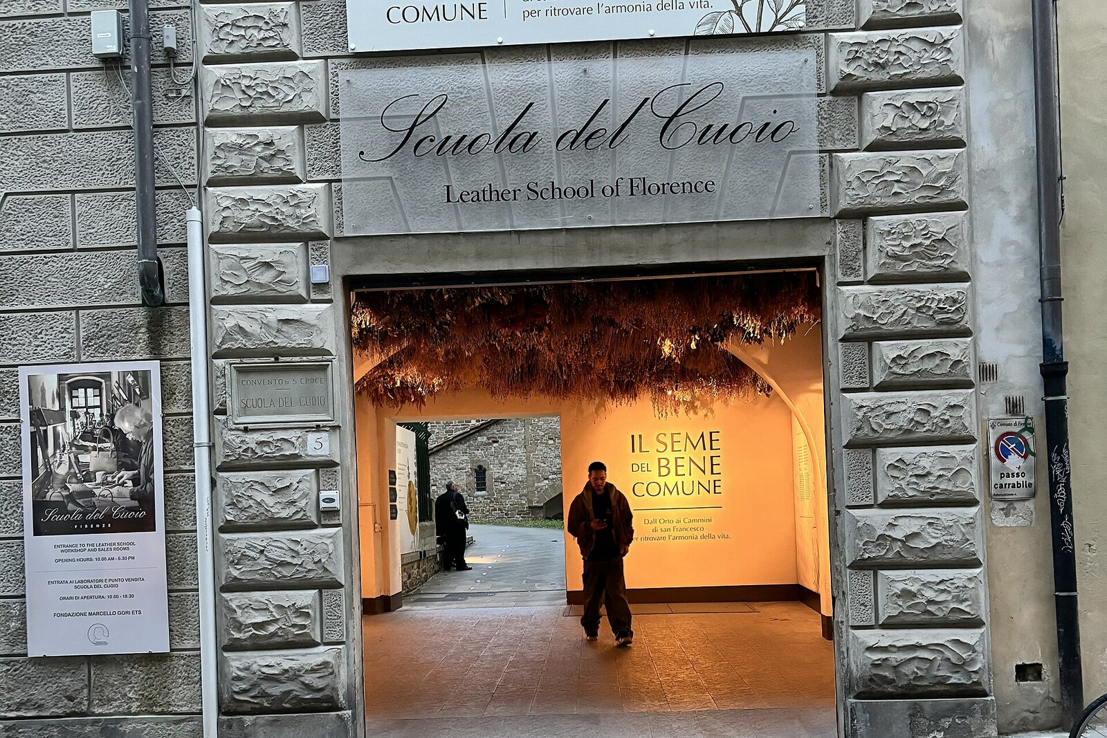 The inner courtyard of the Scuola del Cuoio workshop, with a display of leather bags and workshops.