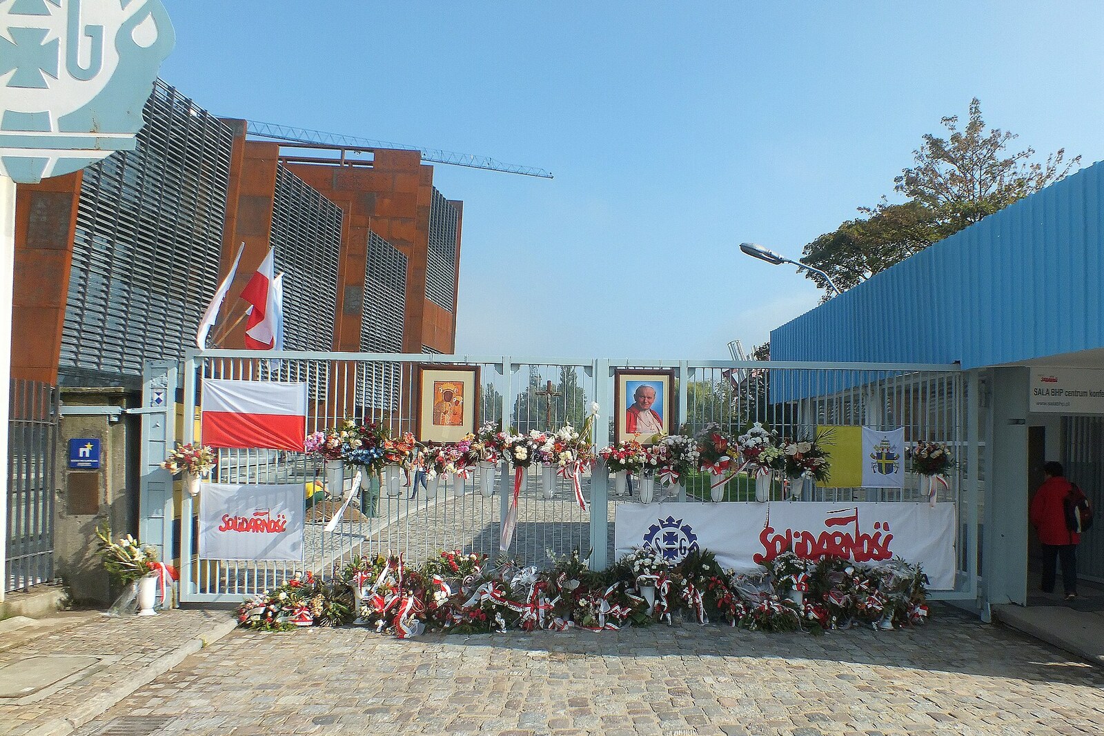 Historisches Tor Nr. 2 der Danziger Werft mit Blumen und Erinnerungsbildern.