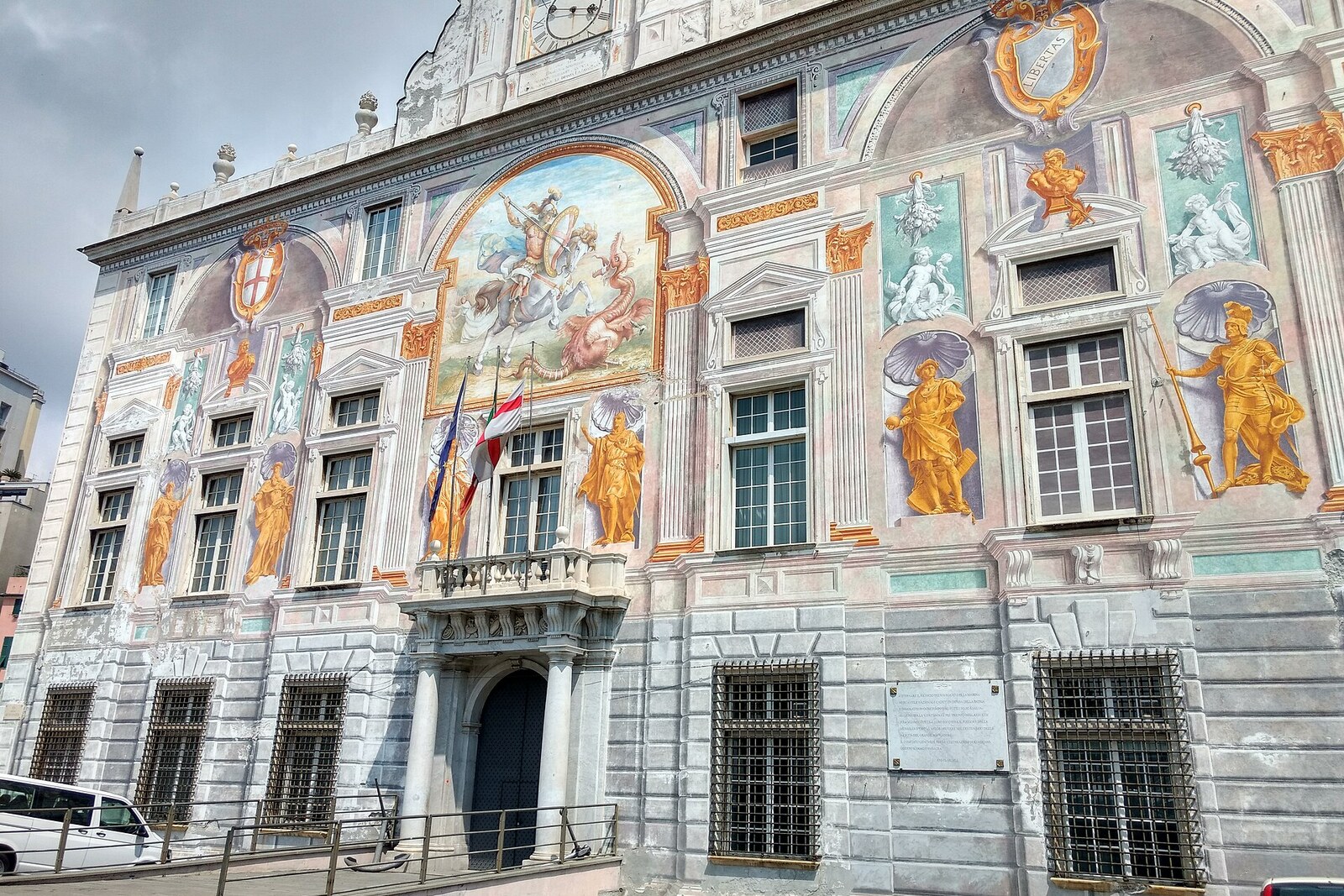 The painted facade of Palazzo San Giorgio by the port.