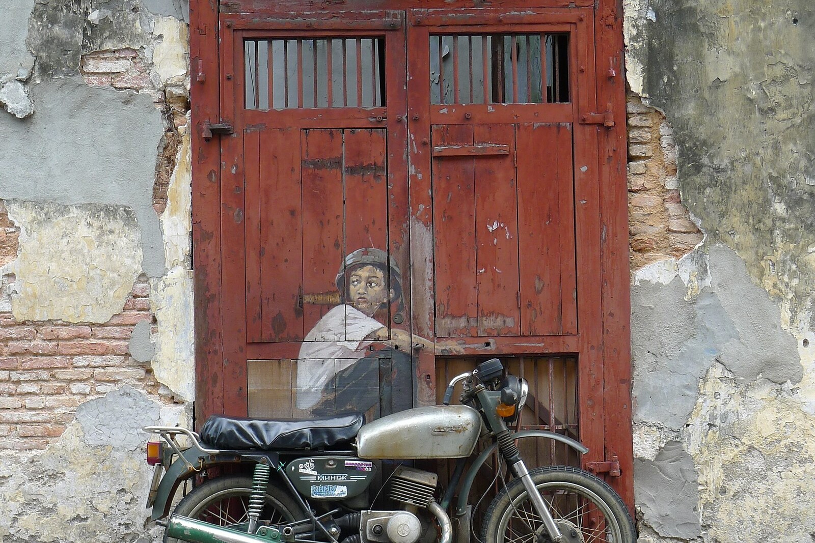 Boy on a Bike mural showing a boy leaning on a motorcycle on Ah Quee Street.