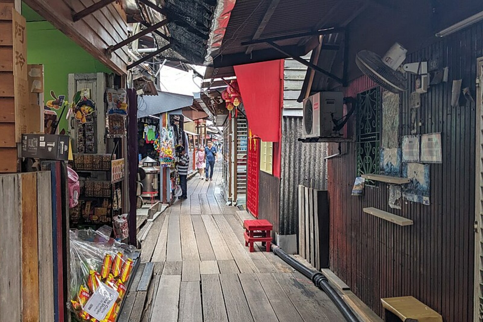 The narrow wooden passageway of Chew Jetty between stilt houses